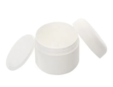 Empty white container with open lid, surrounded by two closed lids, on a white background.