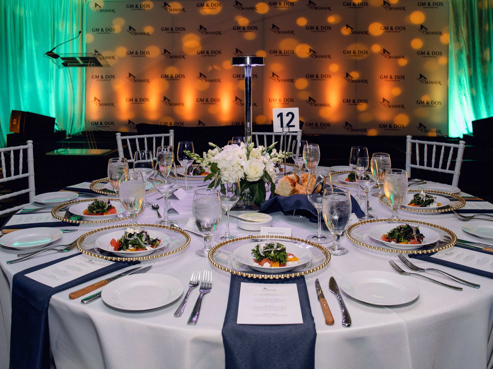 Round dinner table set with flowers and place settings before a gala