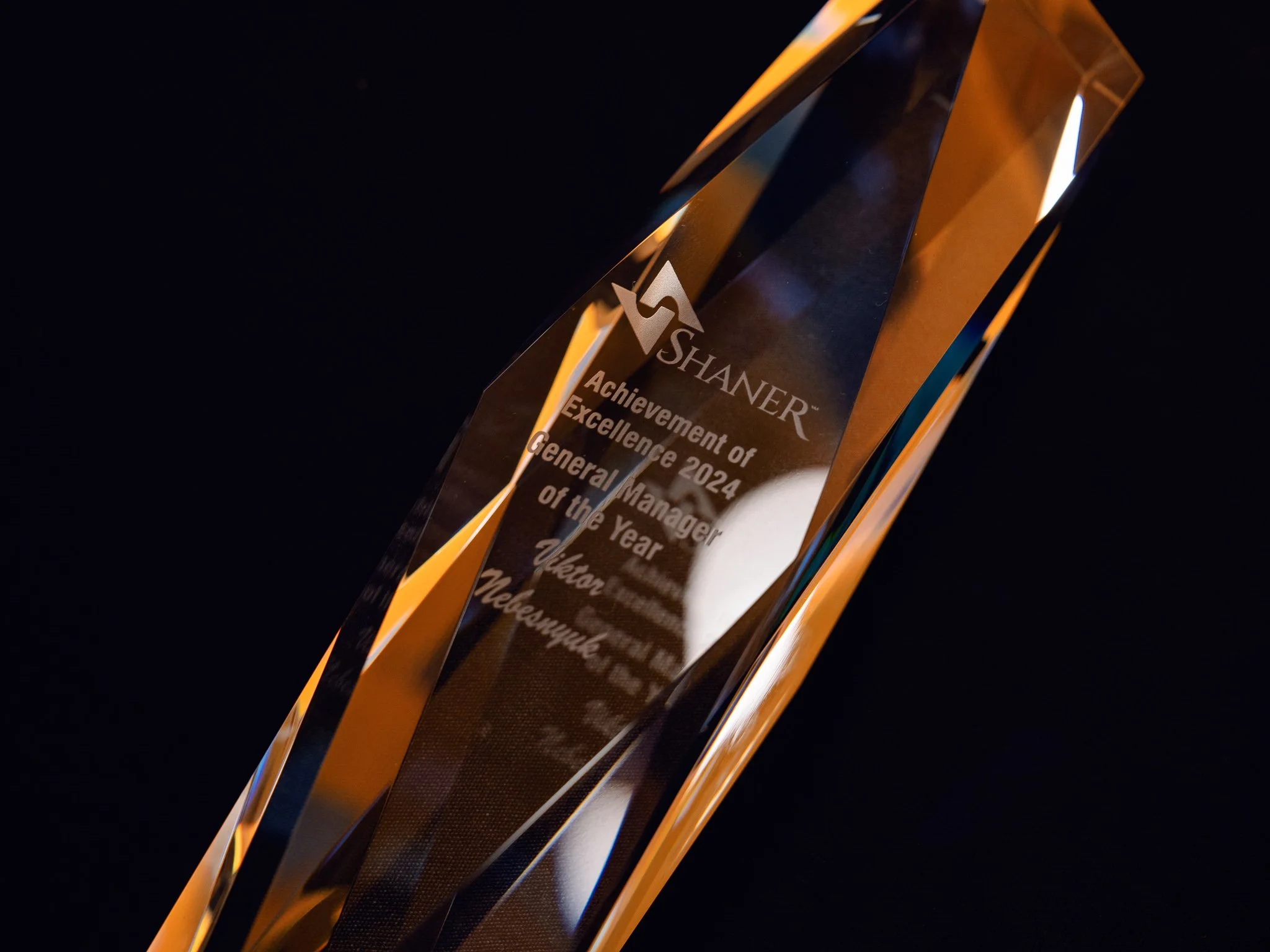 Close up of a crystal award trophy lit in amber