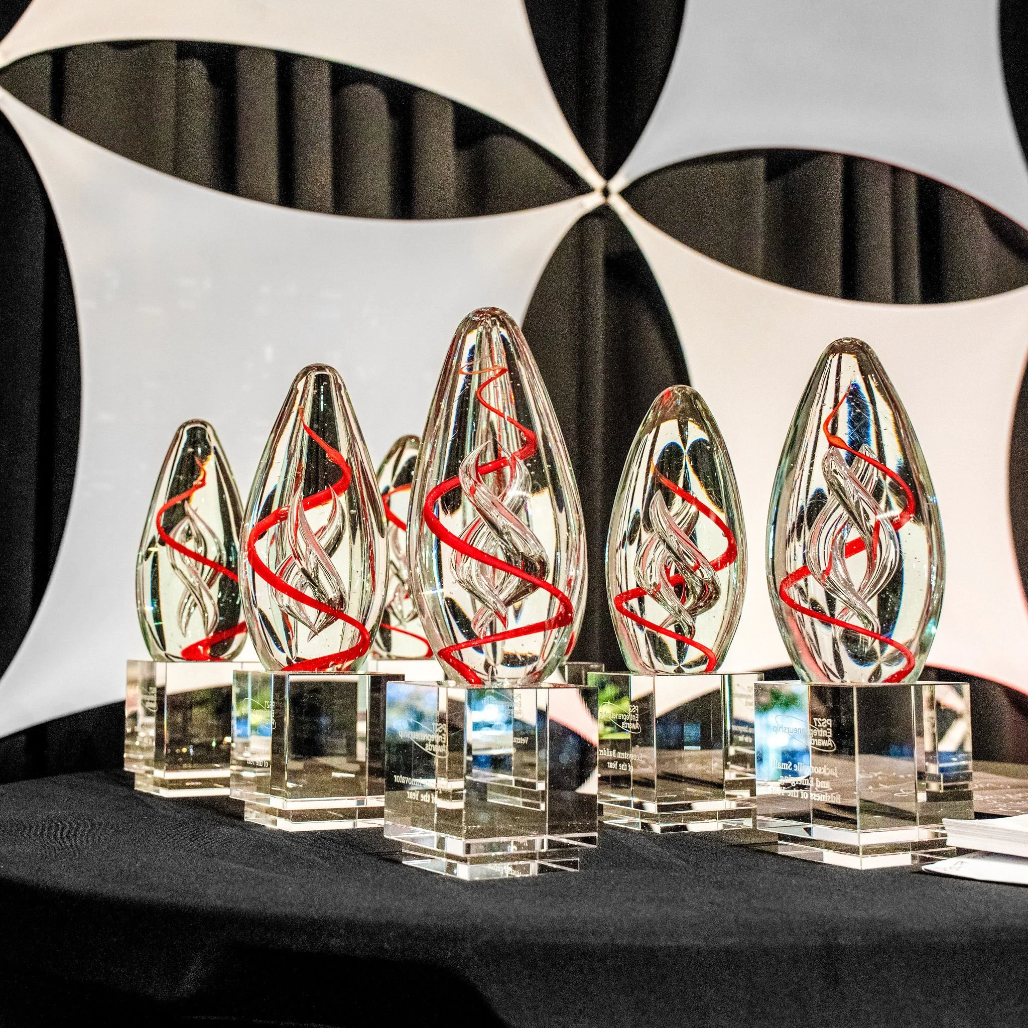 Row of crystal award trophies on a black table