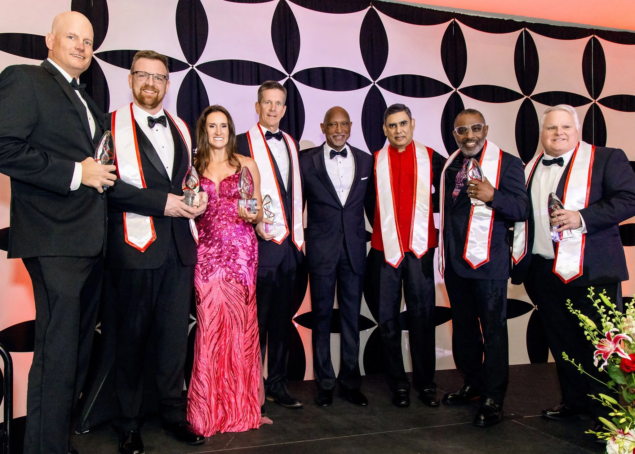 Award recipients in sashes posing together on stage
