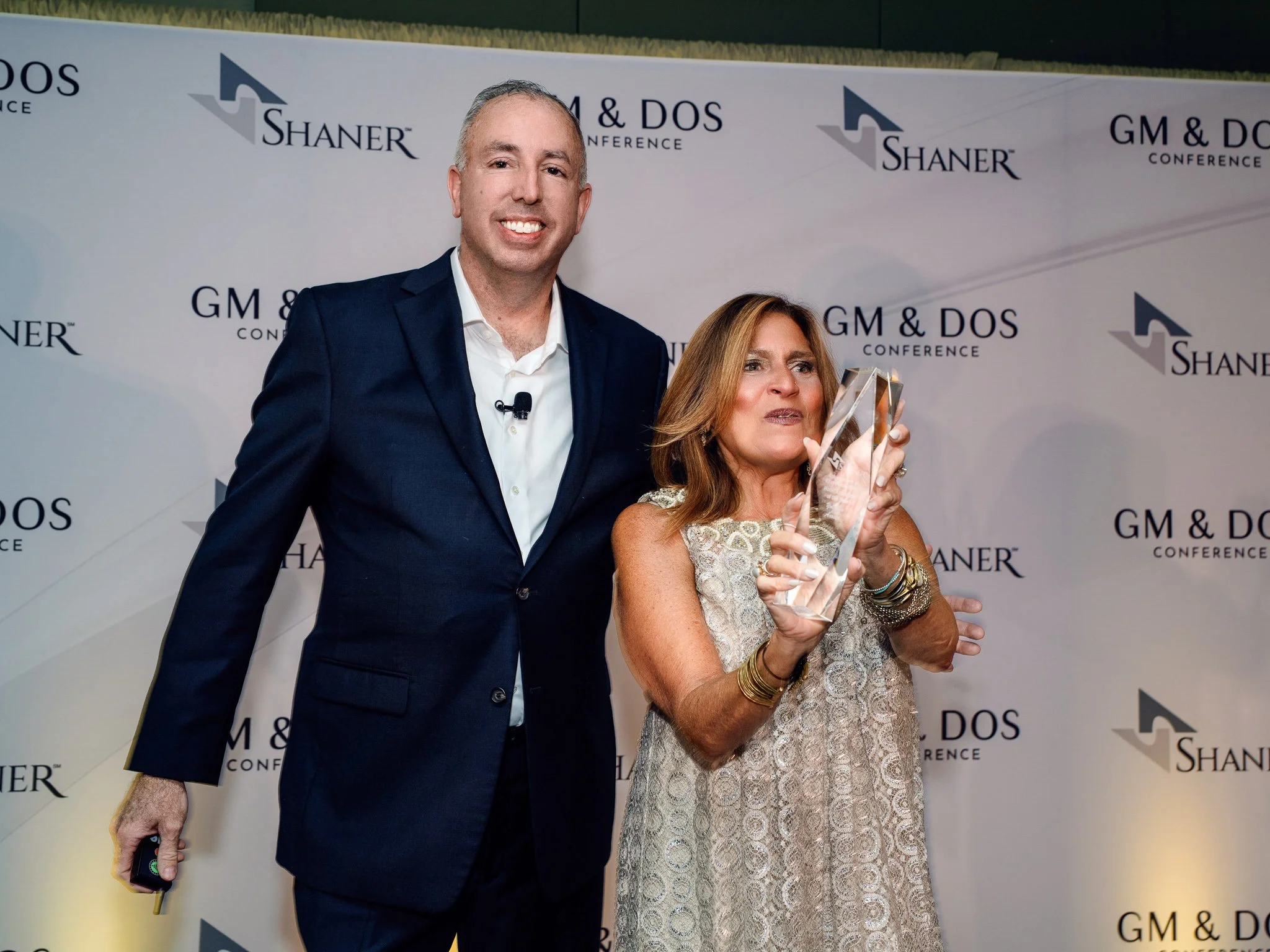 Couple holding an award at a conference gala