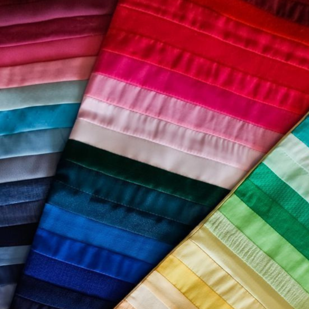 Colorful fabric swatches organized by color, including shades of pink, blue, green, yellow, and neutral.