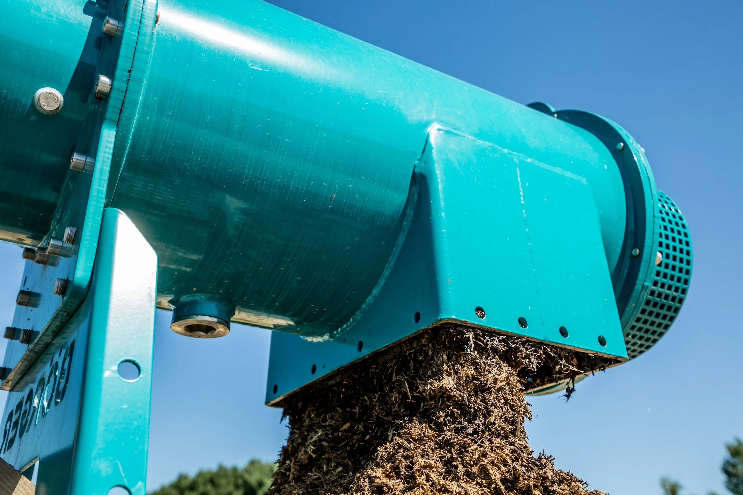 Biogas feedstock being ejected from feeder