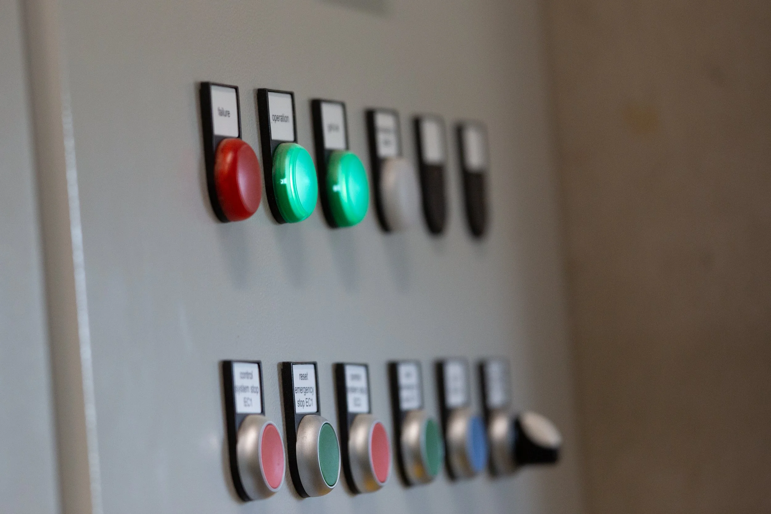 Electrical switch board, lights illuminated showing on and off, green and red button to switch off parts of an AD plant