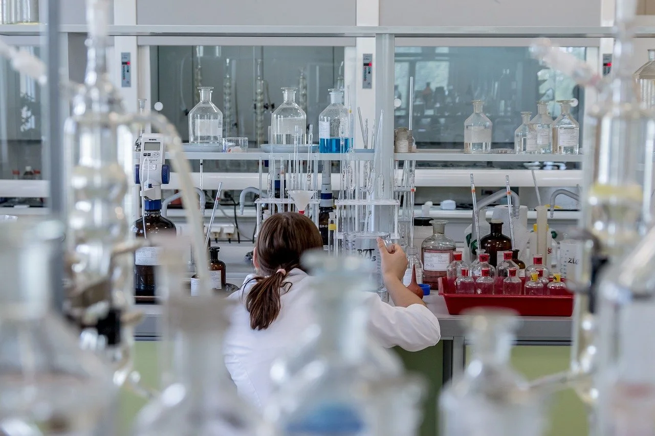 lab with test tubes, person wearing white lab coat