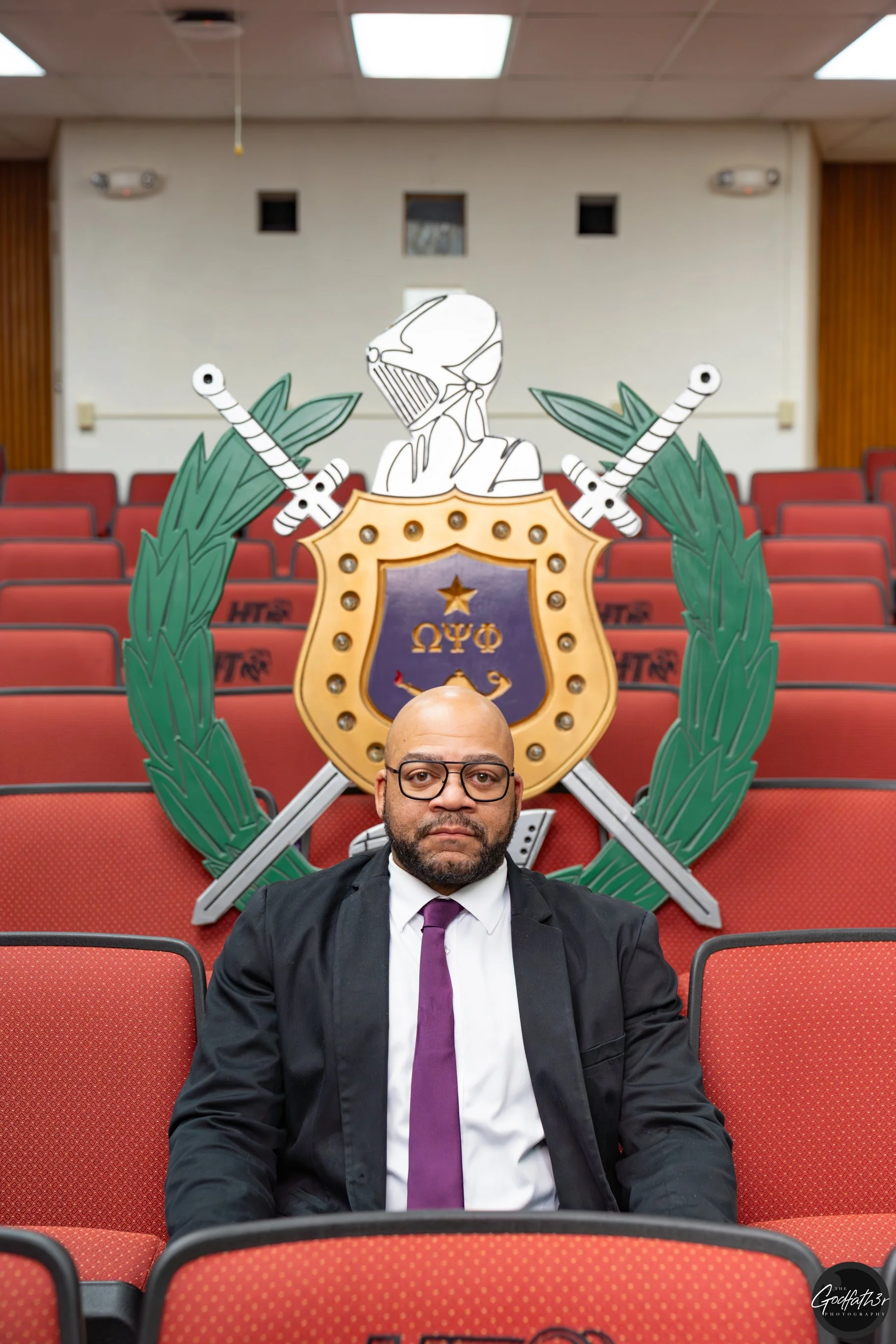 Silhouette of a man in a suit and tie, with a golden halo-like circle behind him.