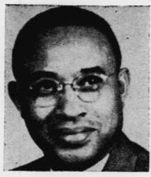 Black and white photograph of a man wearing glasses with short hair, looking at the camera.