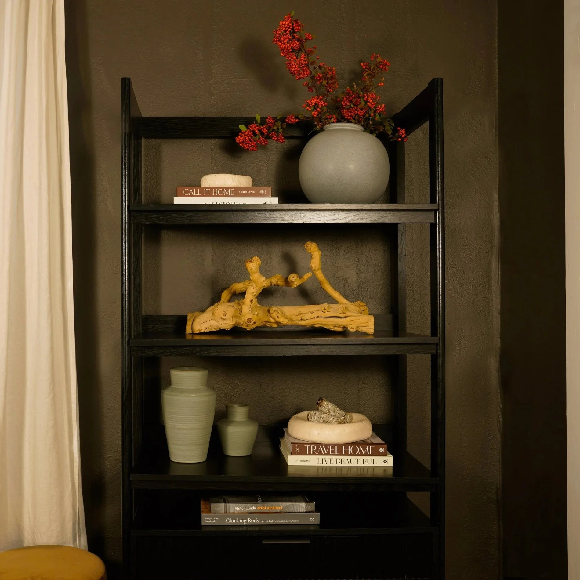 Modern black shelving styled with neutral vases, books, and decorative accents, demonstrating professional home staging and elevated interior design styling.