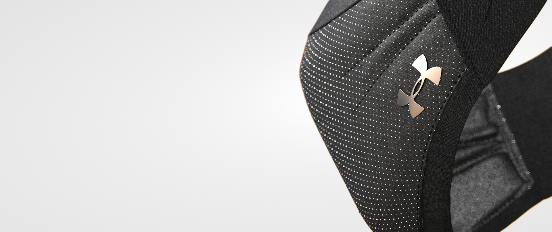 Close-up of a black Under Armour sports bag with a metallic logo on the front, featuring small white dots and a textured surface.