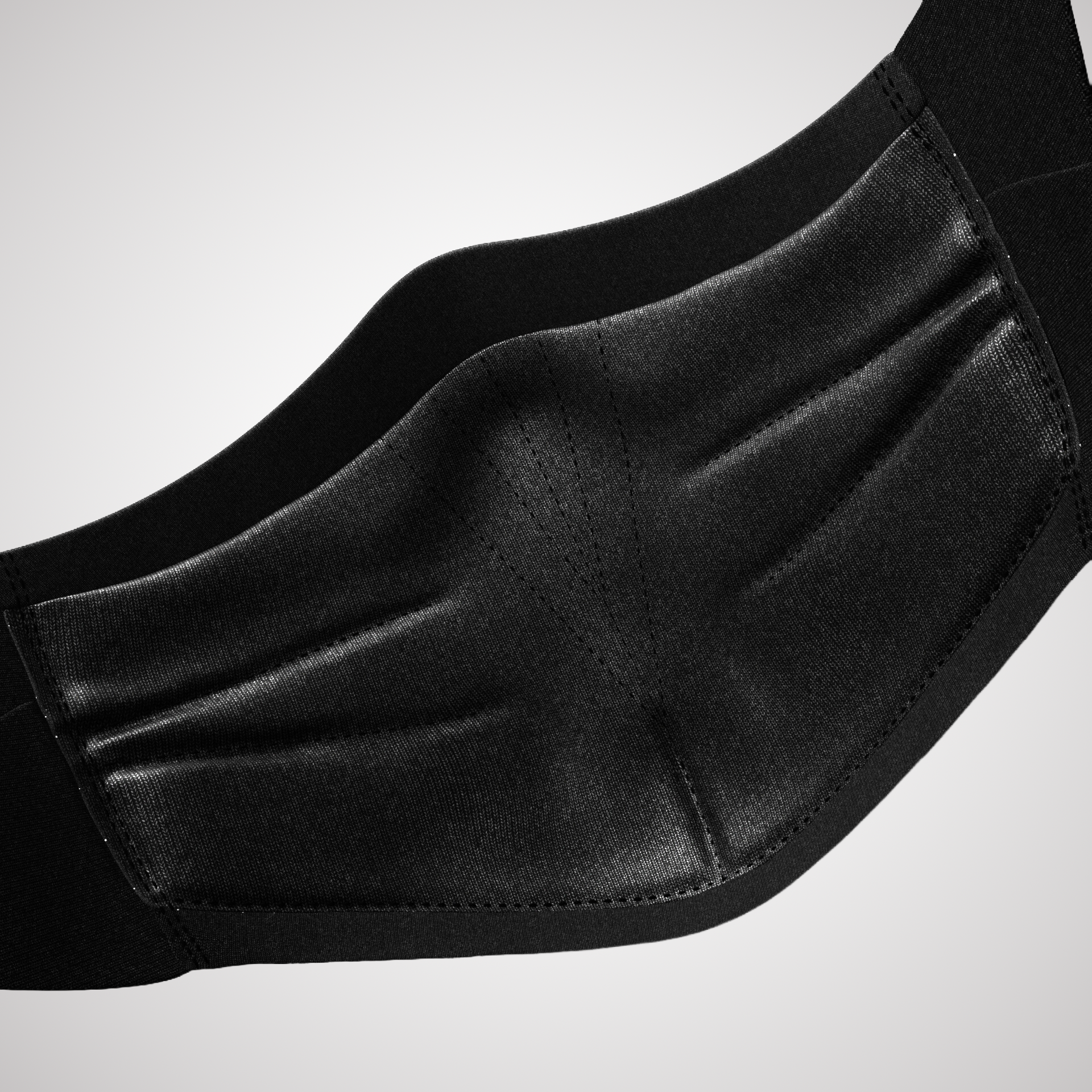 Close-up of a black face mask made of fabric and leather, with detailed stitching.