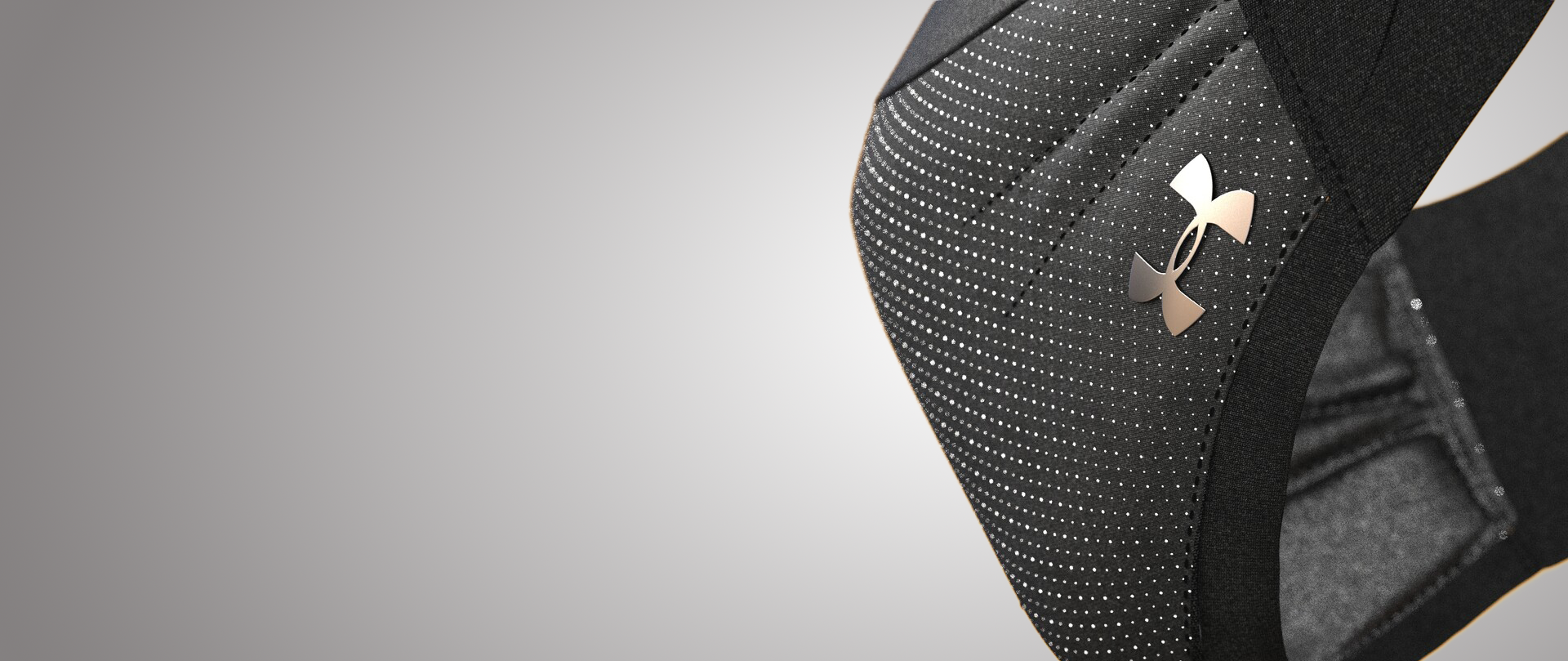 Close-up of a black Under Armour sports bag with a silver logo, featuring a dotted pattern design.