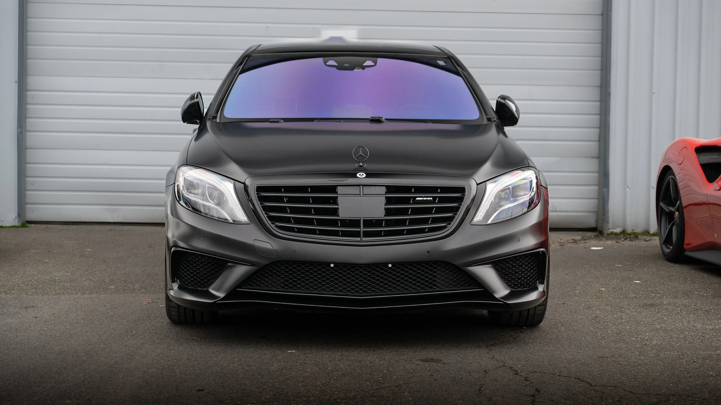 Front view of a Vinyl Wrapped matte black Mercedes sedan with premium windshield tint installed at Tailored Garage in South Hill, Puyallup WA.