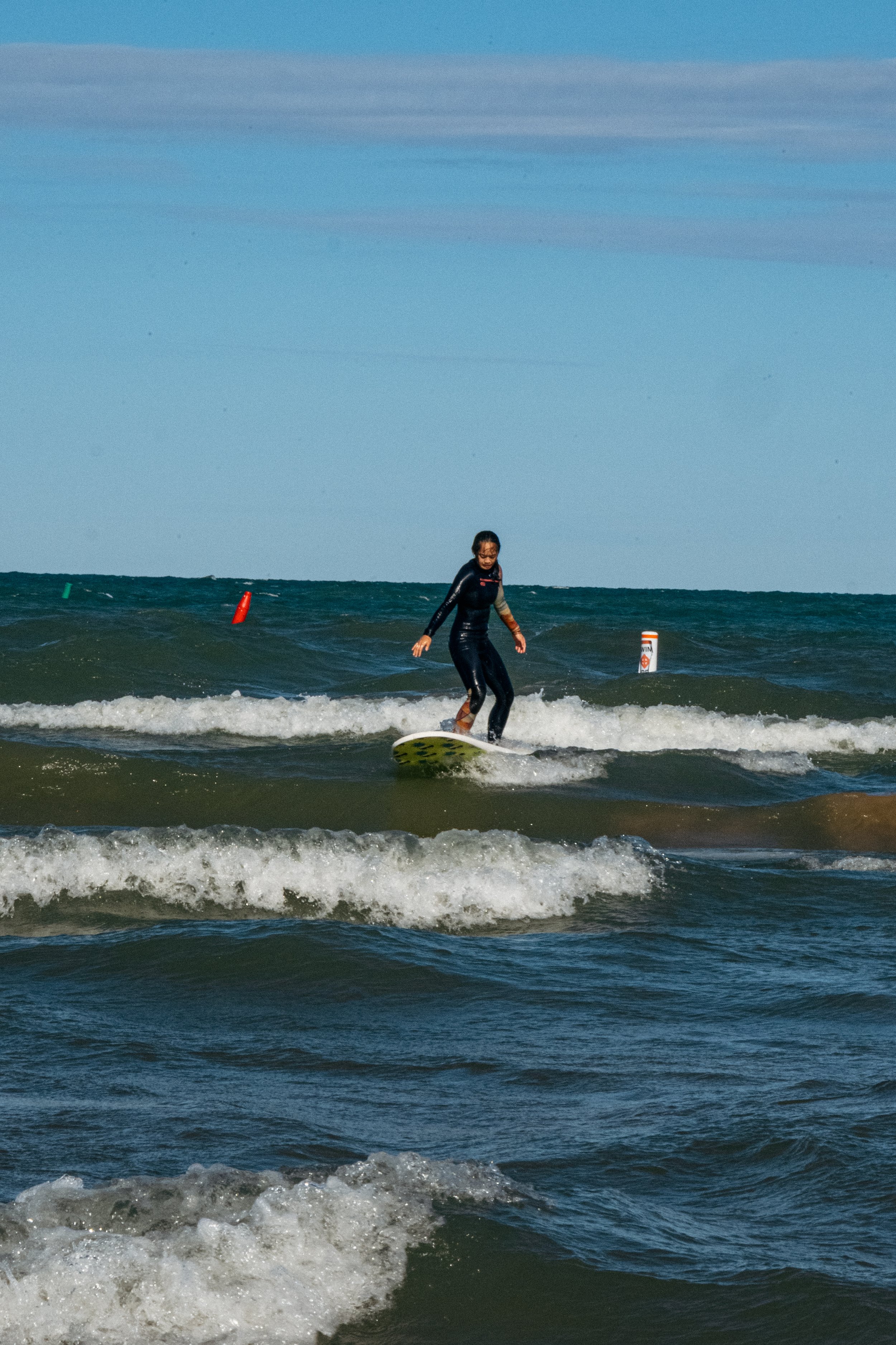 A woman surfing on small waves at the beach during daytime.