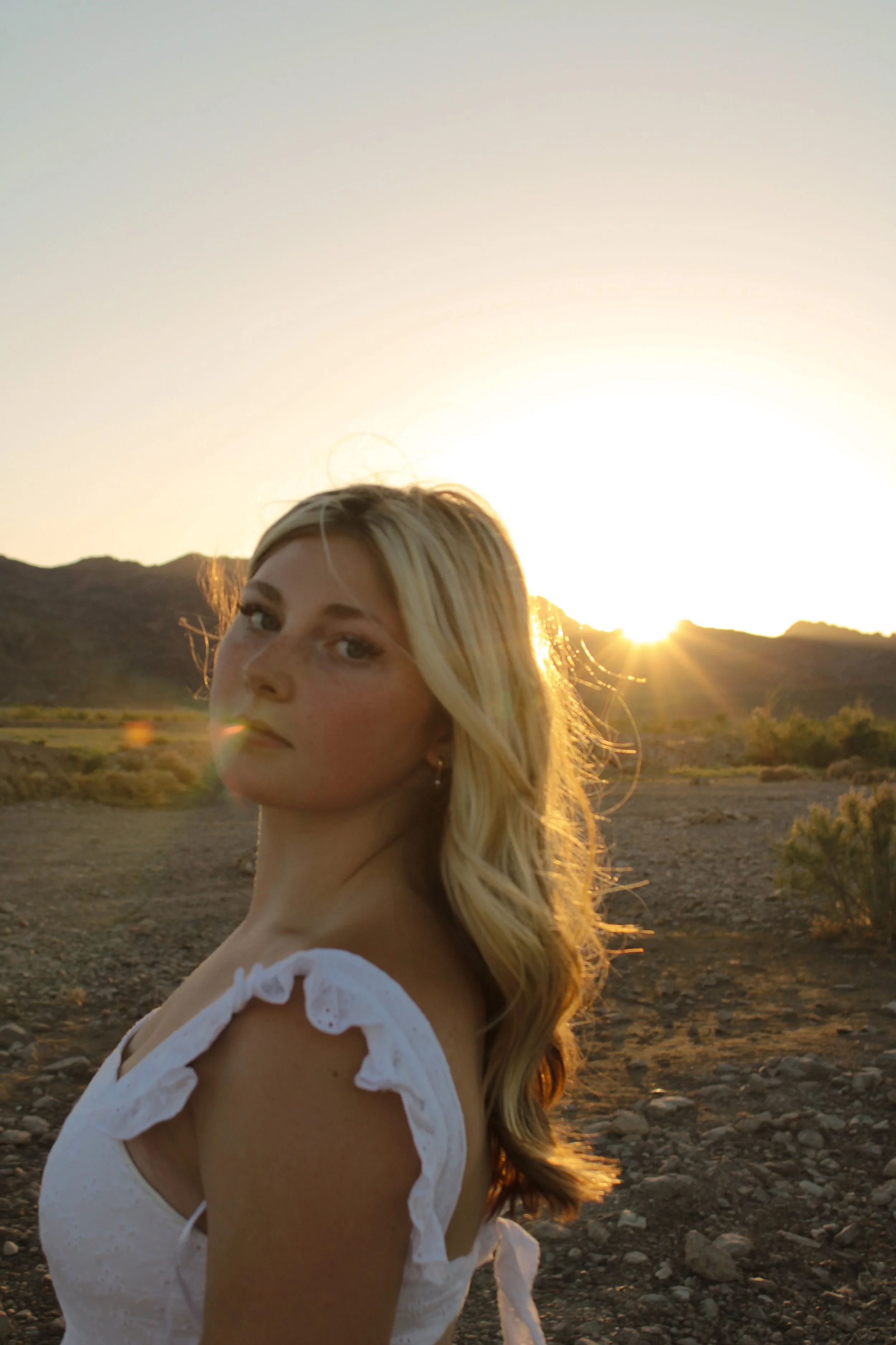 Kayla Cox looking at the camera during sunset in the desert.
