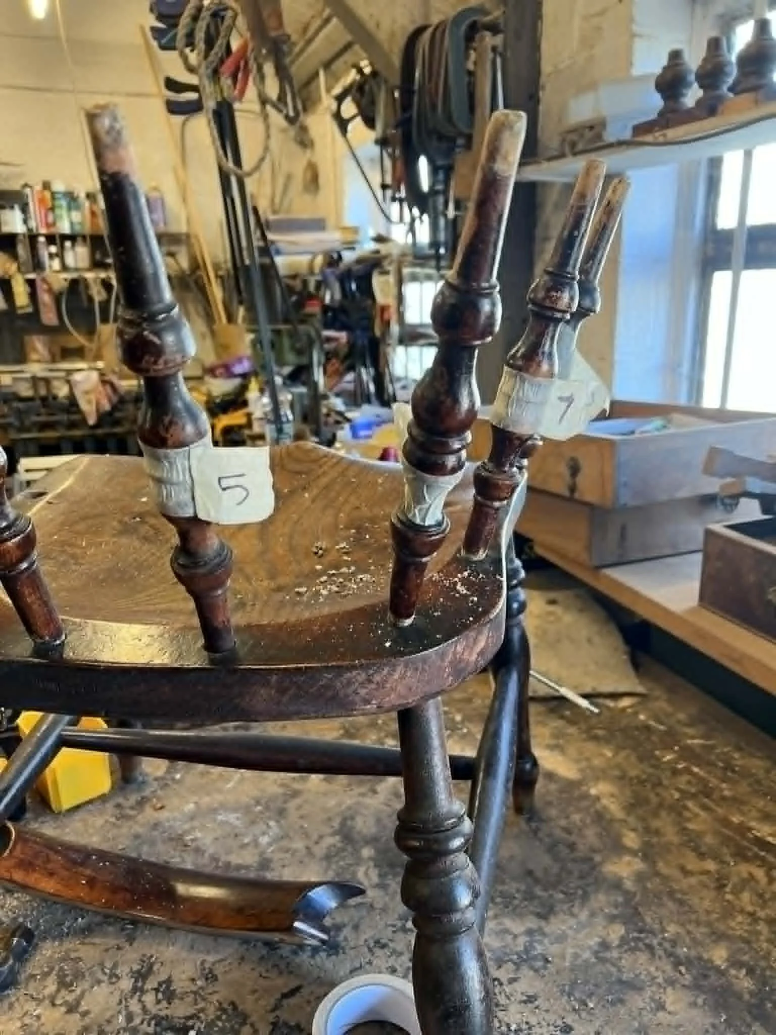 An antique dining chair frame undergoing stabilization and re-gluing to fix wobbly joints and ensure long-term structural integrity.
