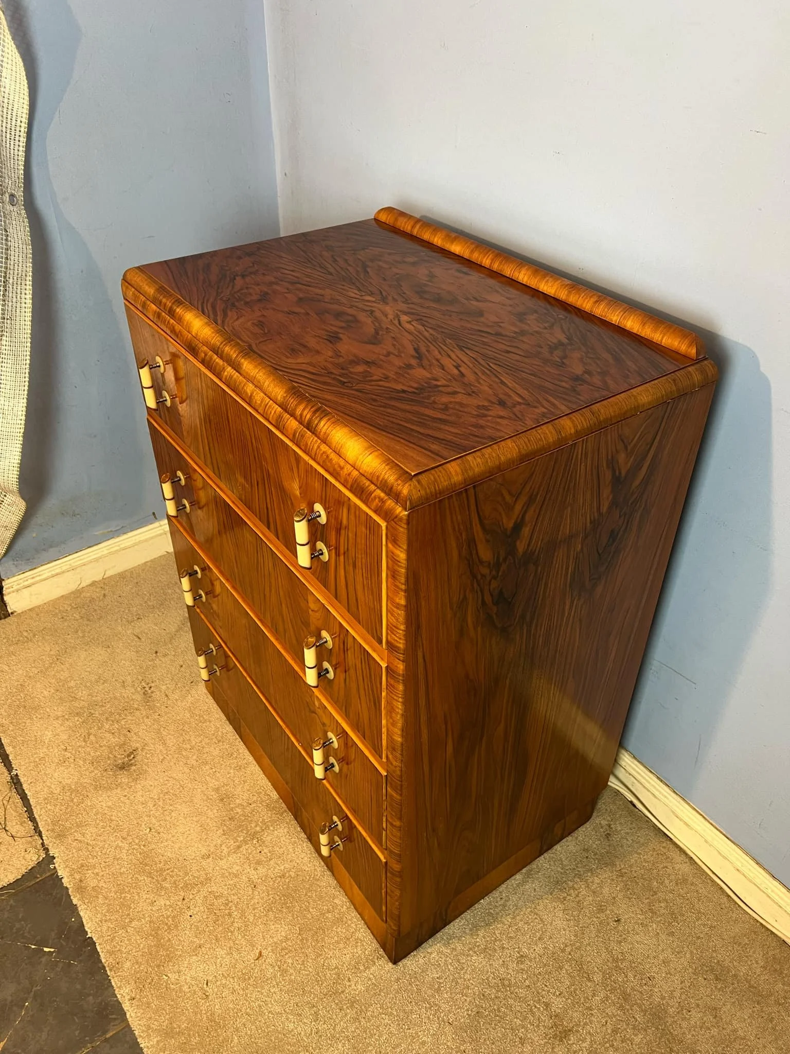 Angled view showing the high-gloss French polished top and side grain of a restored Art Deco chest of drawers - Master restoration Kent