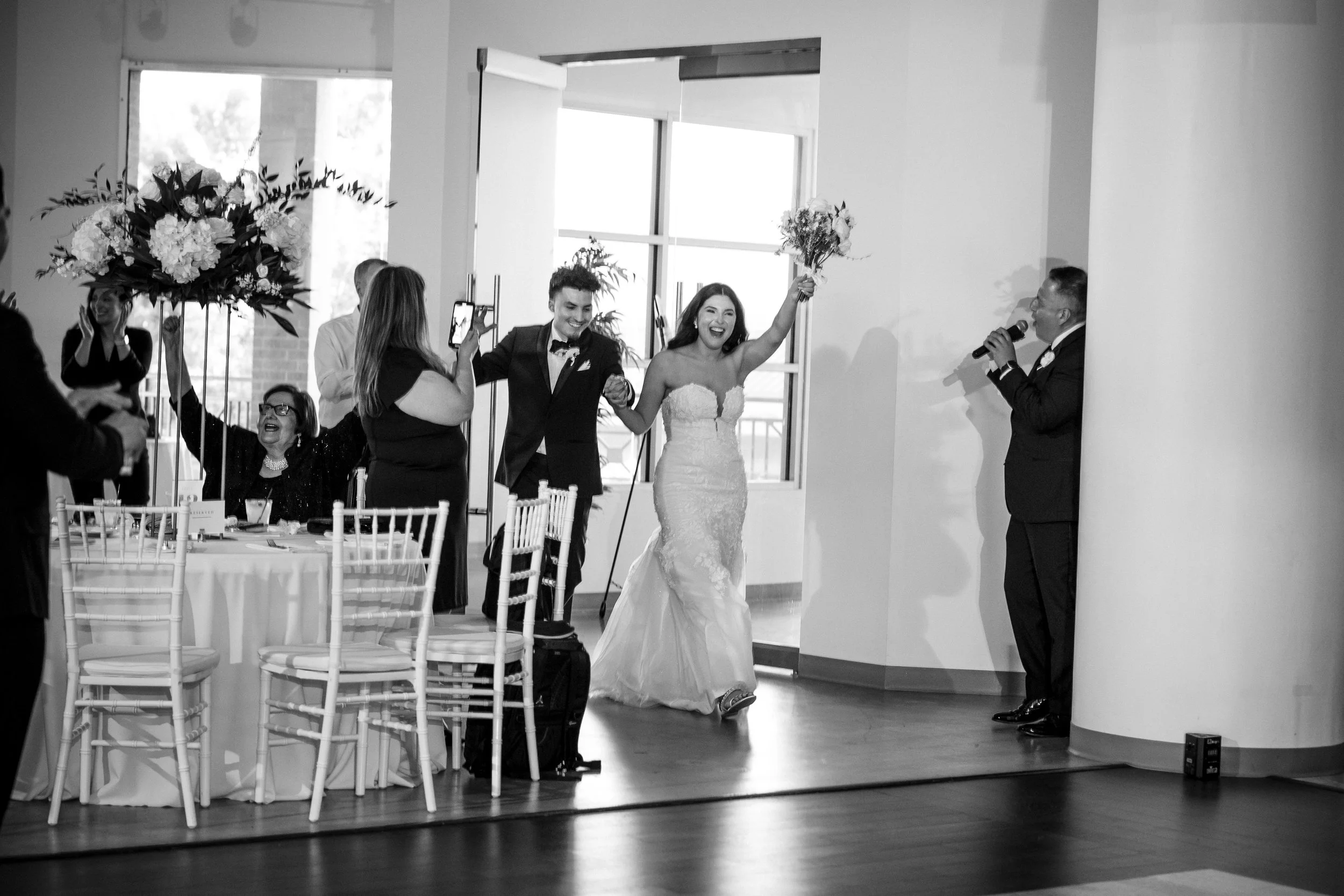 Bride and groom making their grand entrance as the DJ welcomes them to their wedding reception at Level Two