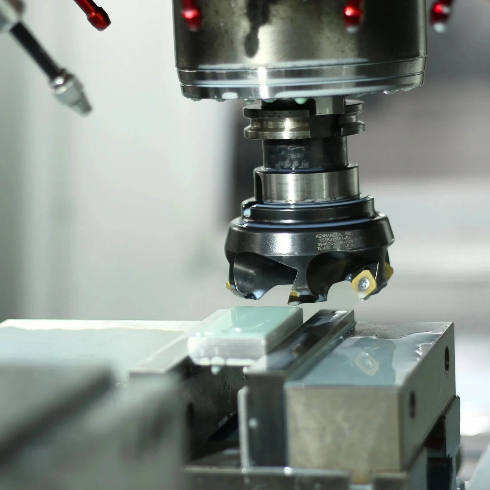 A close-up of a CNC machine cutting a rectangular piece of material with a rotary cutter.