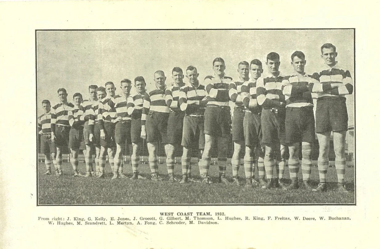 Black and white photo of the West Coast rugby team, 1932, standing outdoors on a field in rugby uniforms with striped shirts and shorts, with arms crossed.