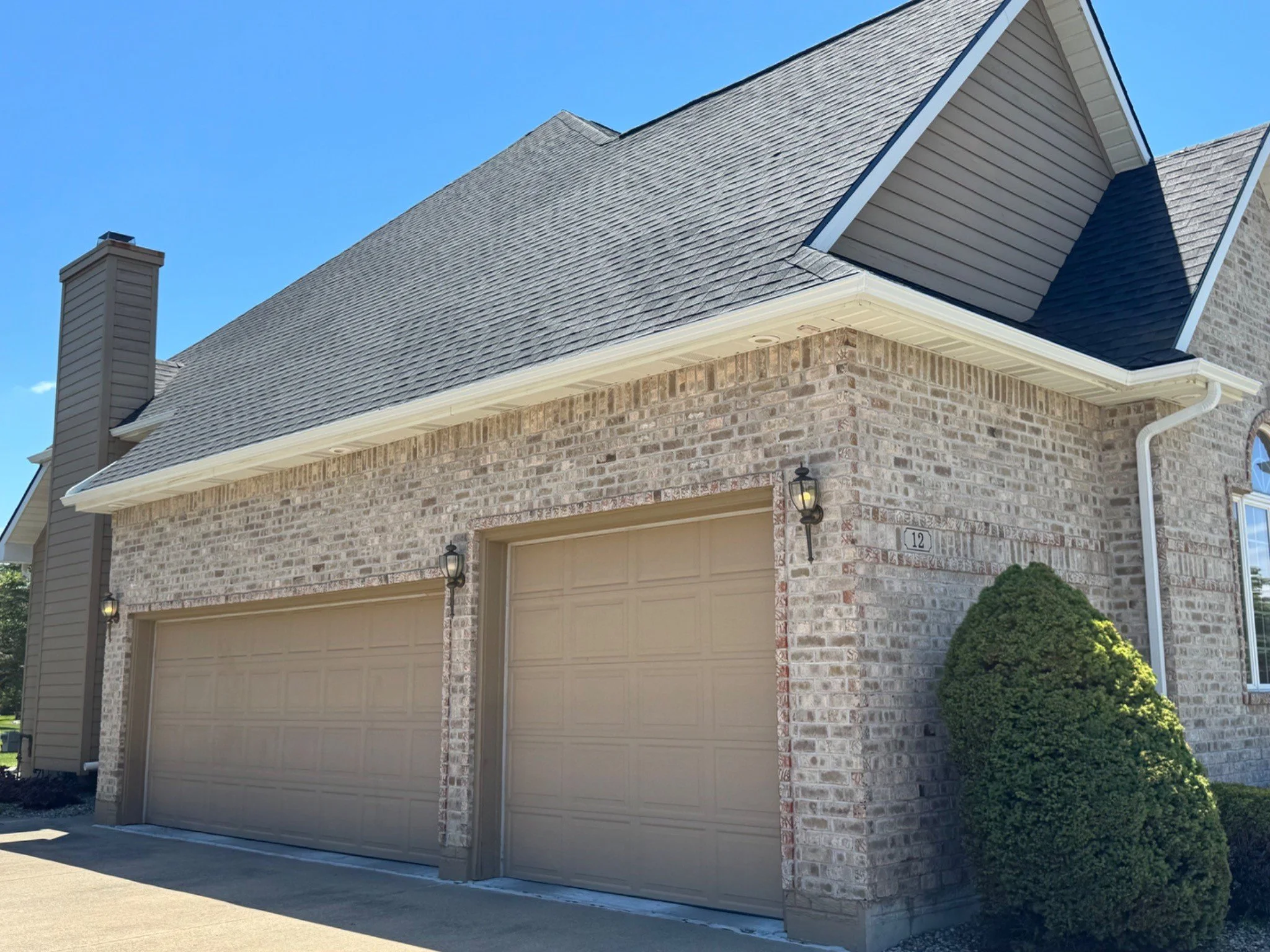 Gutter and downspout installation above a three-car garage in Saginaw Township, Michigan