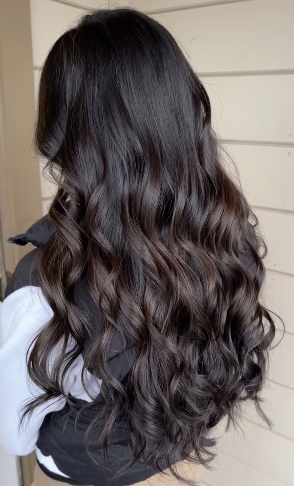 A woman with long, dark, wavy hair.