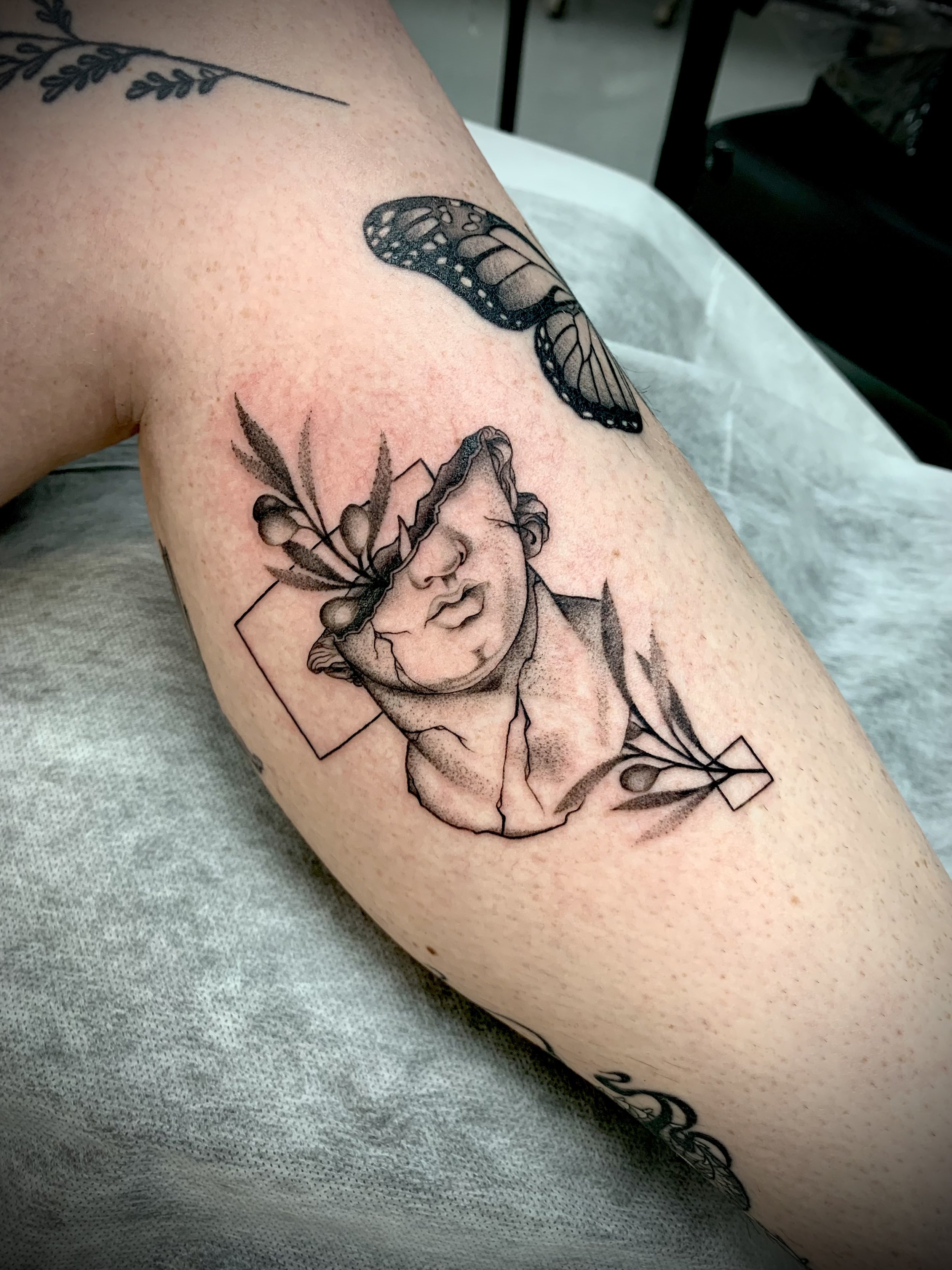 Black and grey fine line surrealism illustrative Greek statue tattoo olive branch tattoo