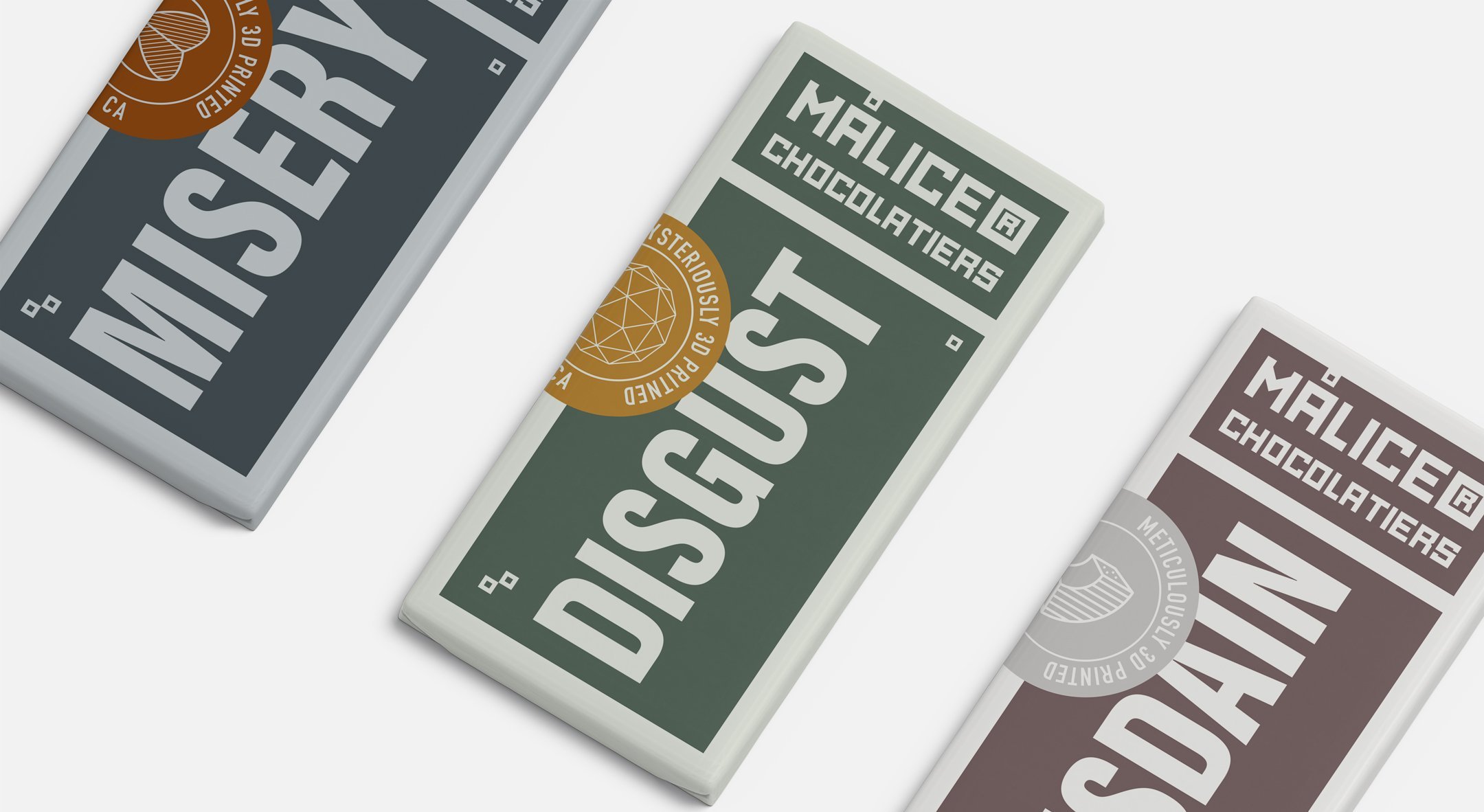 Series of MALICE Chocolates bars labeled Misery, Disgust, and Disdain in a minimalist brand system.