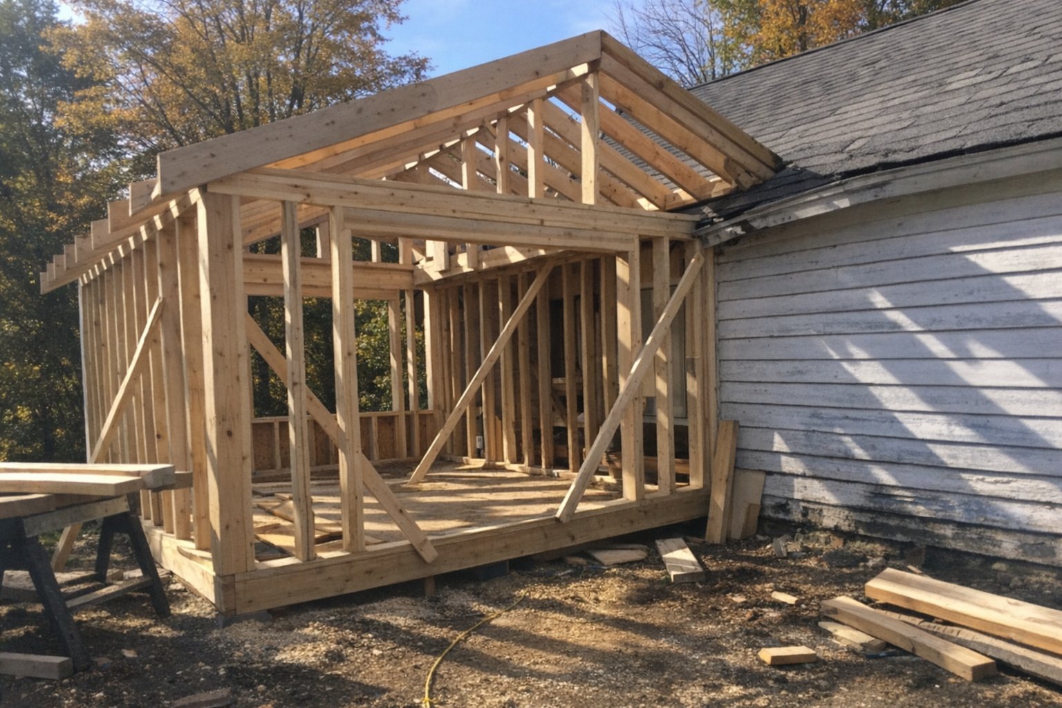 New addition framing tied into an older clapboard house