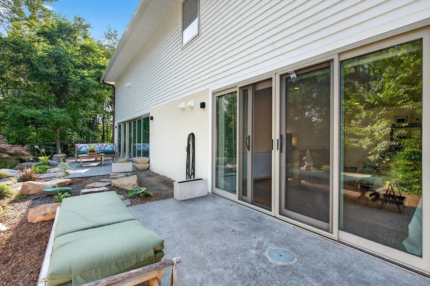 Sliding glass doors opening to a stone patio at Minnewaska, a deep energy retrofit in Kerhonkson by P.A.S Design Build.