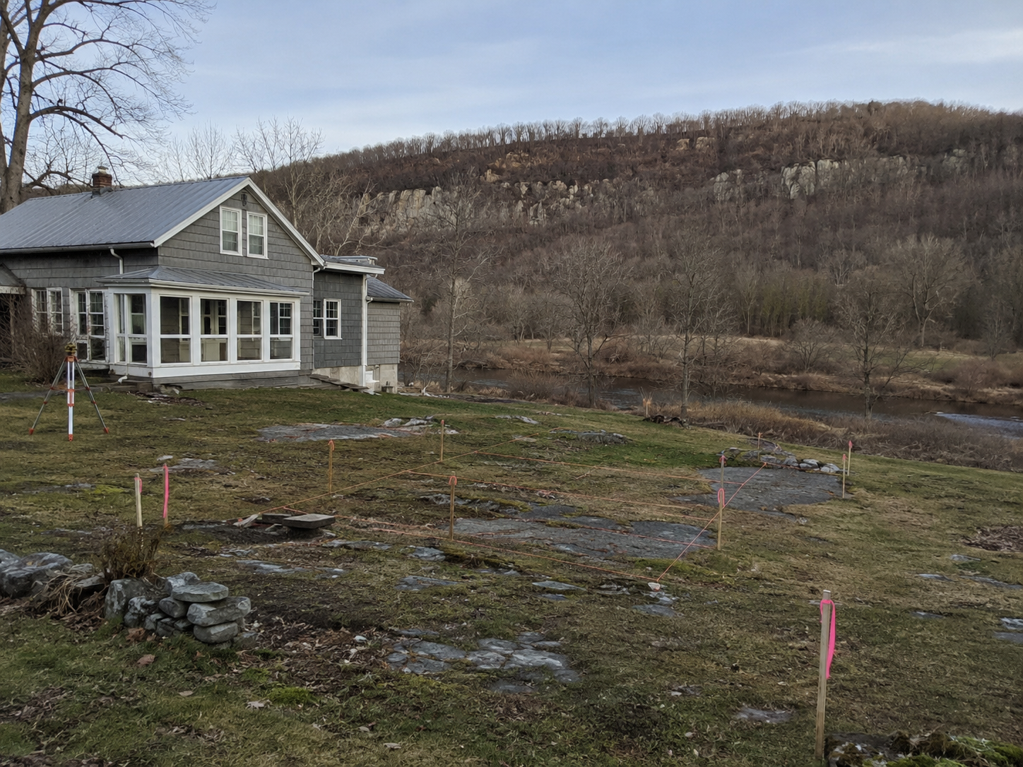 Rural Rosendale, NY property with exposed bedrock, survey stakes, a nearby creek, and Joppenbergh Mountain in the background.