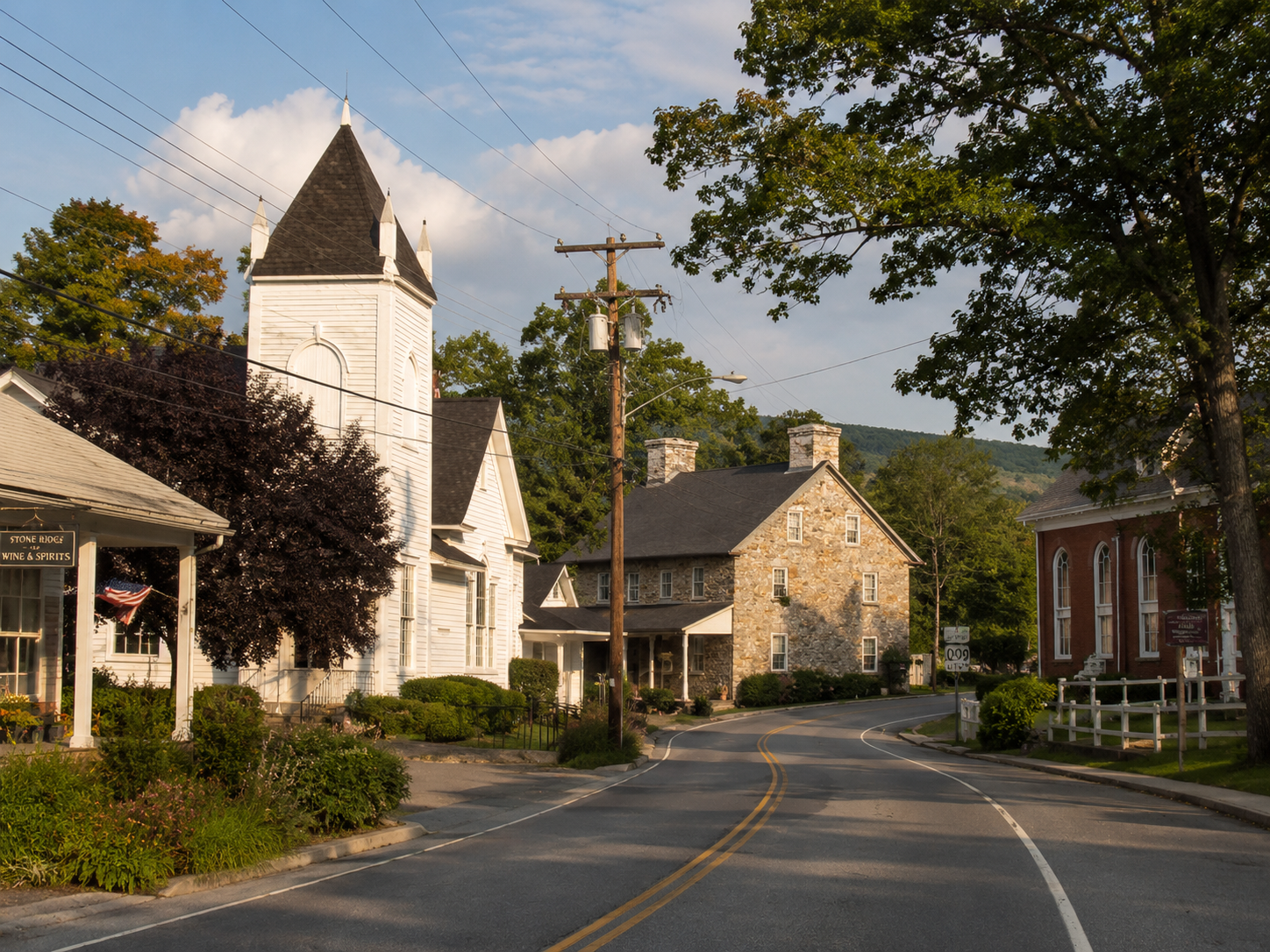 Downtown Stone Ridge, NY streetscape with historic stone and wood buildings, a church tower, mature trees, and the Route 209 corridor.