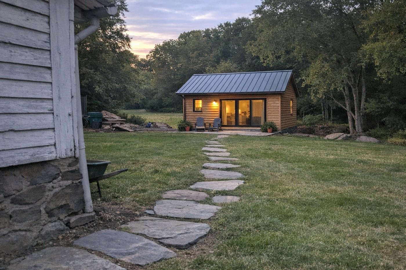 Small detached guest cottage behind an older farmhouse