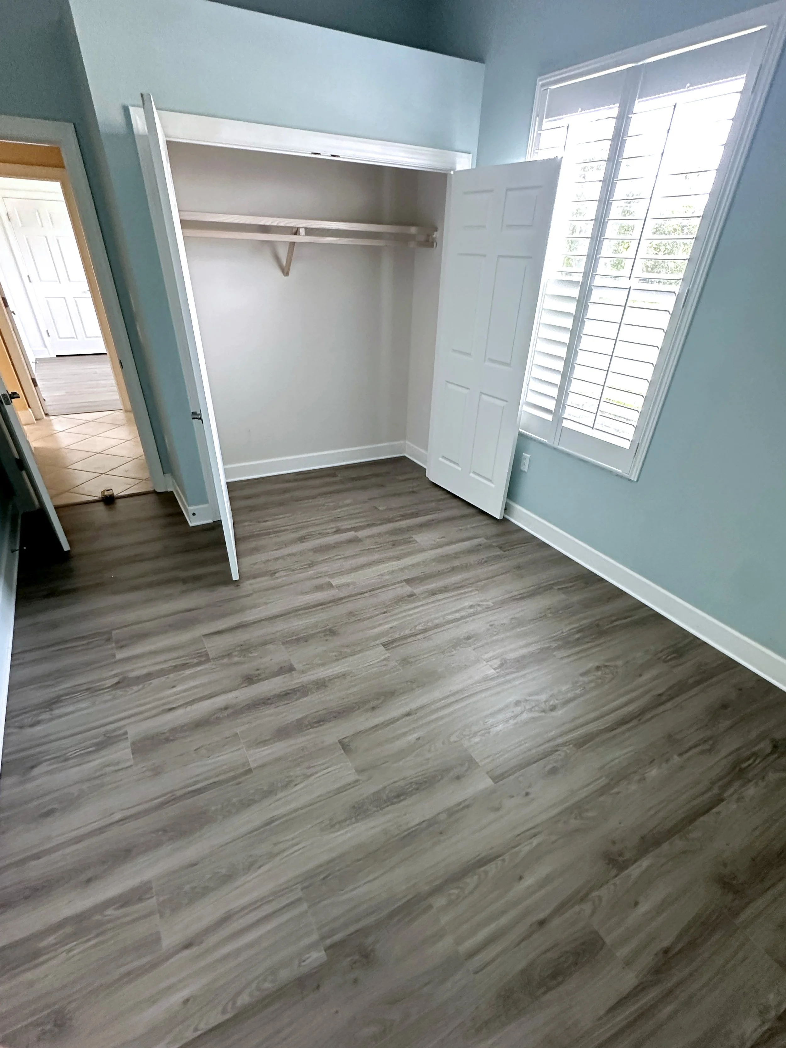 Freshly installed vinyl flooring and trim in a bedroom.