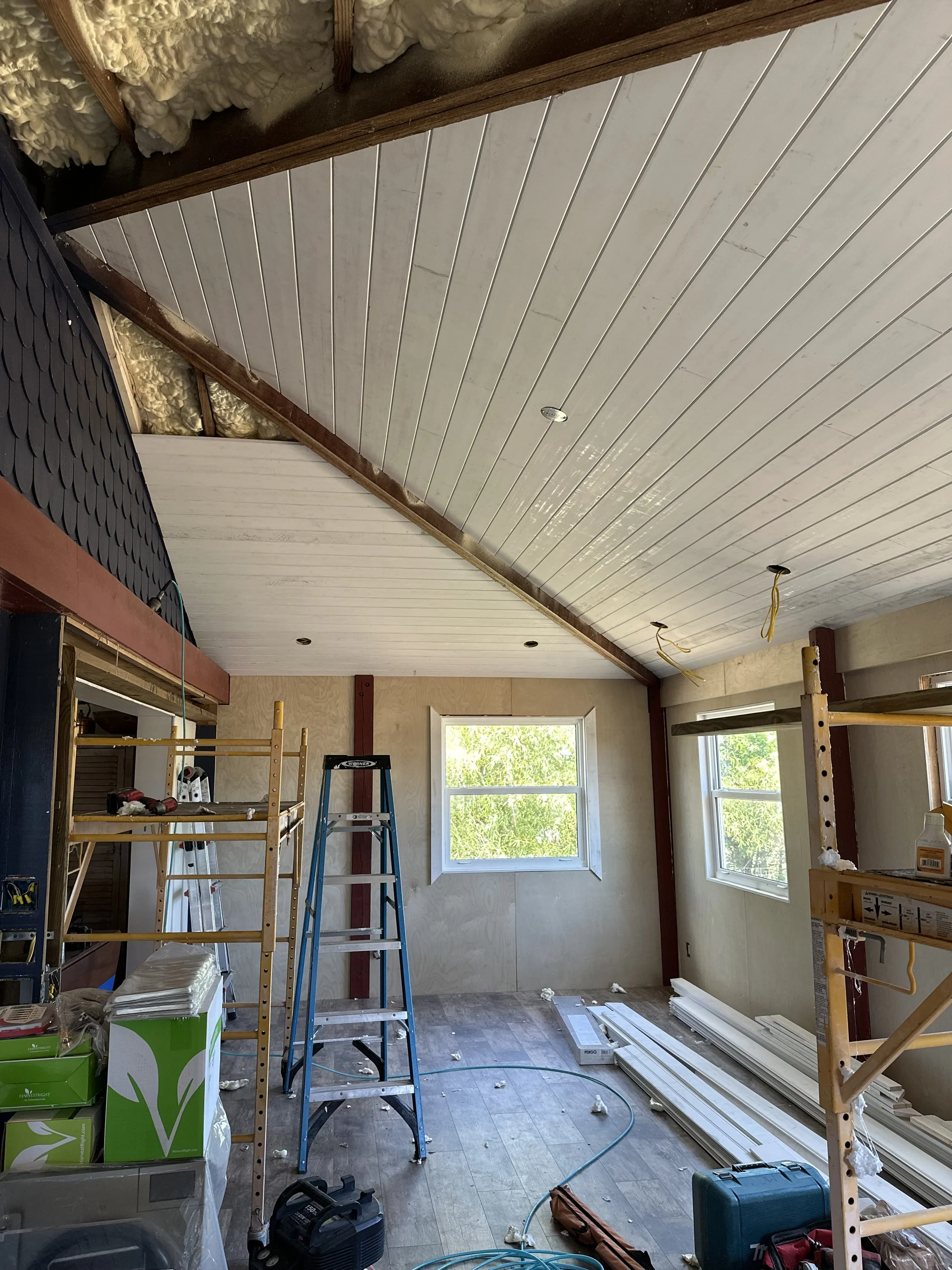Interior of a room under renovation with a tongue and groove ceiling and custom trim through out.