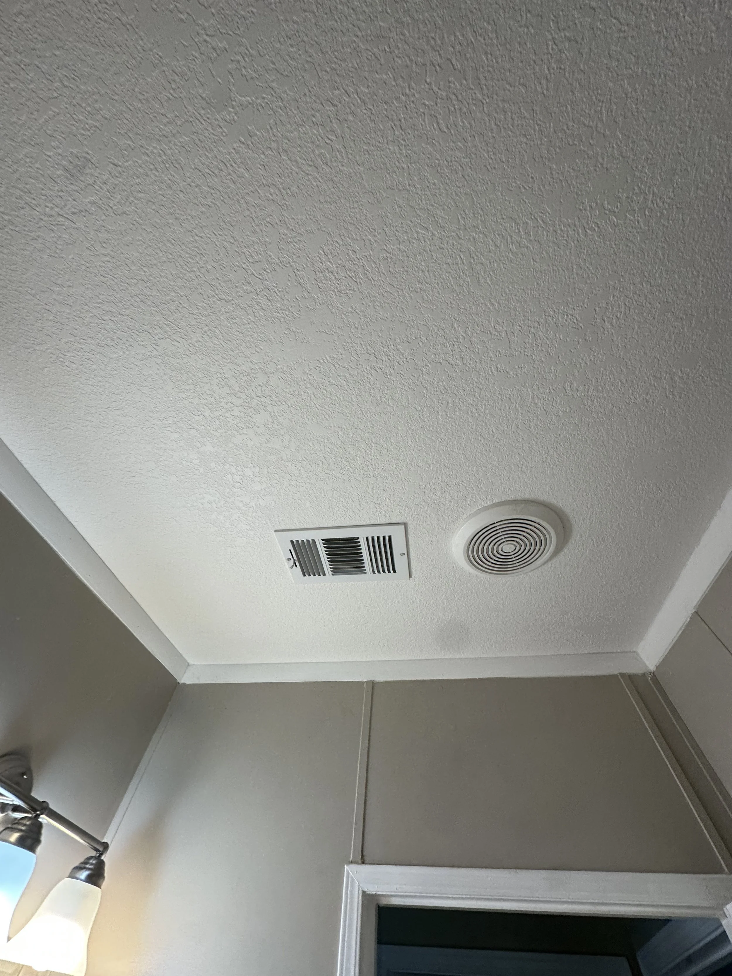 Newly finished knockdown texture on a bathroom ceiling.