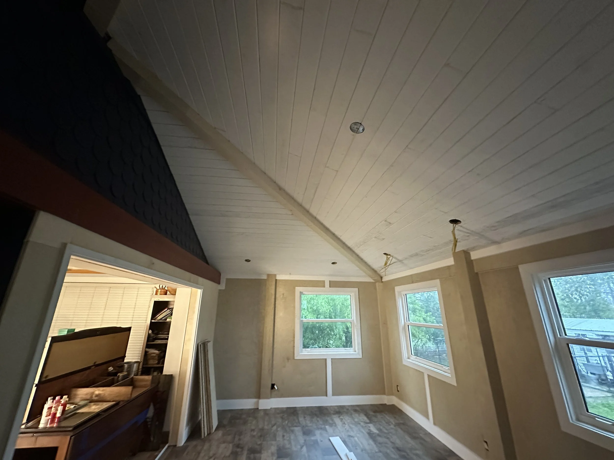 Interior of a room under renovation with a tongue and groove ceiling and custom trim through out.