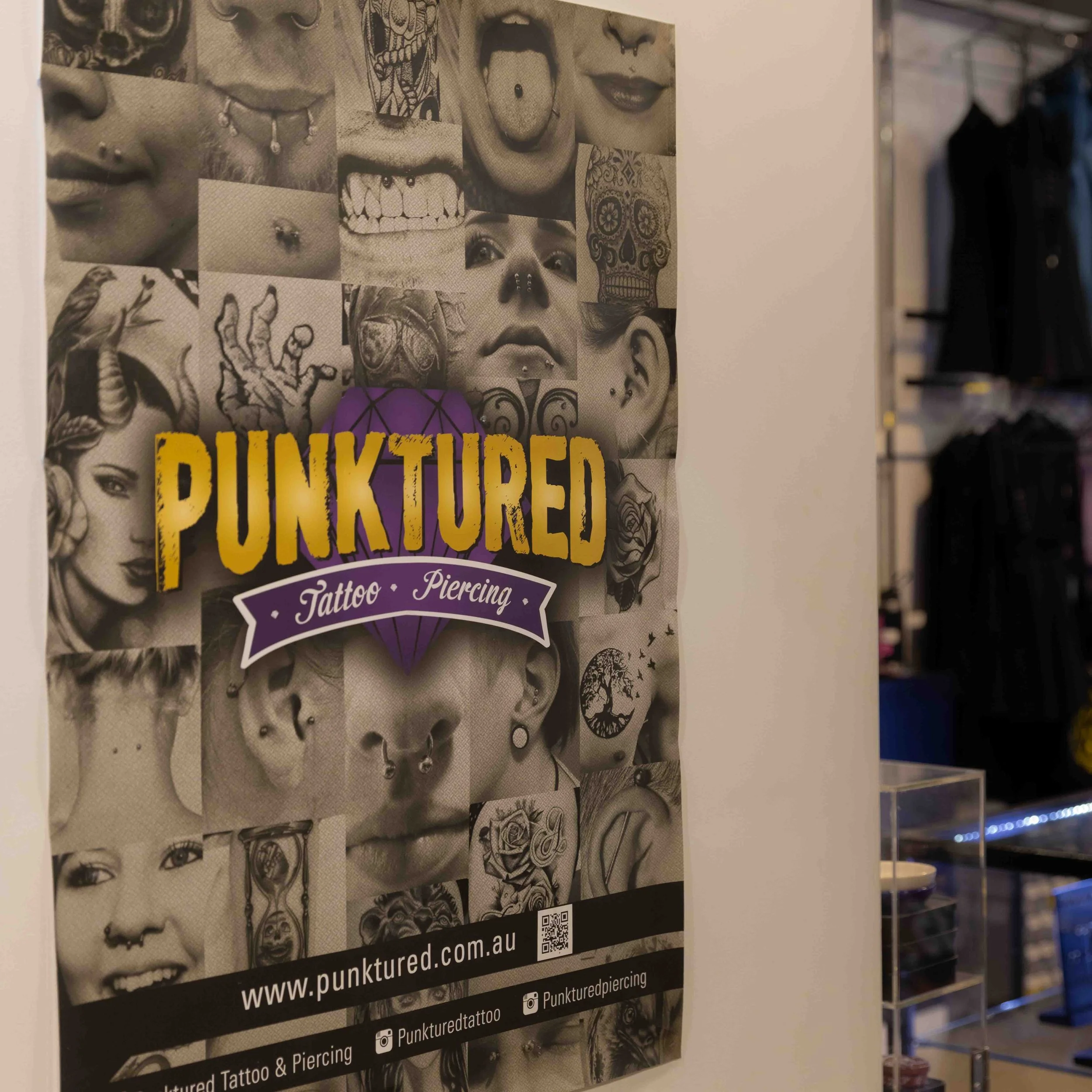 Poster for a tattoo and piercing studio called Punktured, featuring a collage of black and white images of various tattoos and piercings, with colorful text and graphics highlighting the business name and website.