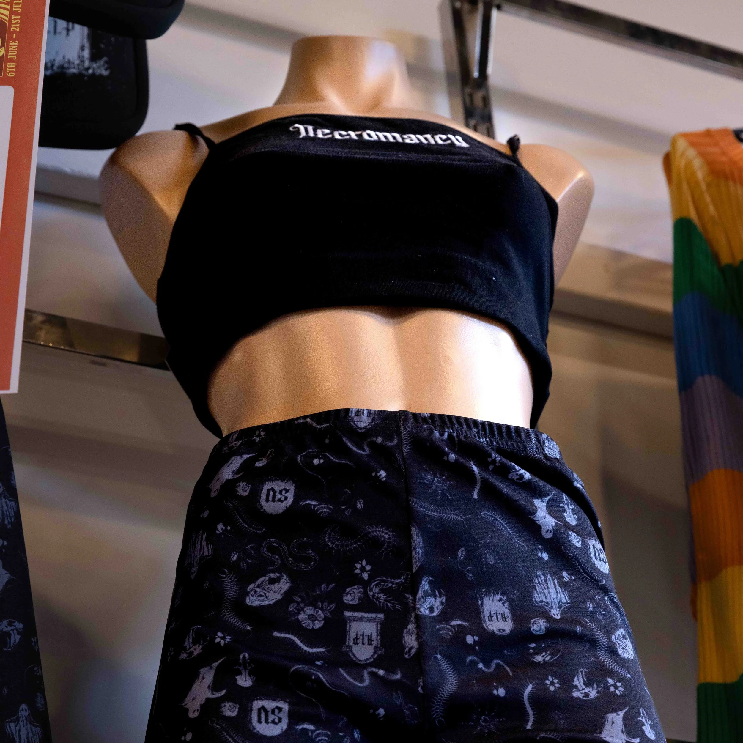 Mannequin dressed in a black tank top and black shorts with white graphic patterns, displayed in a store.