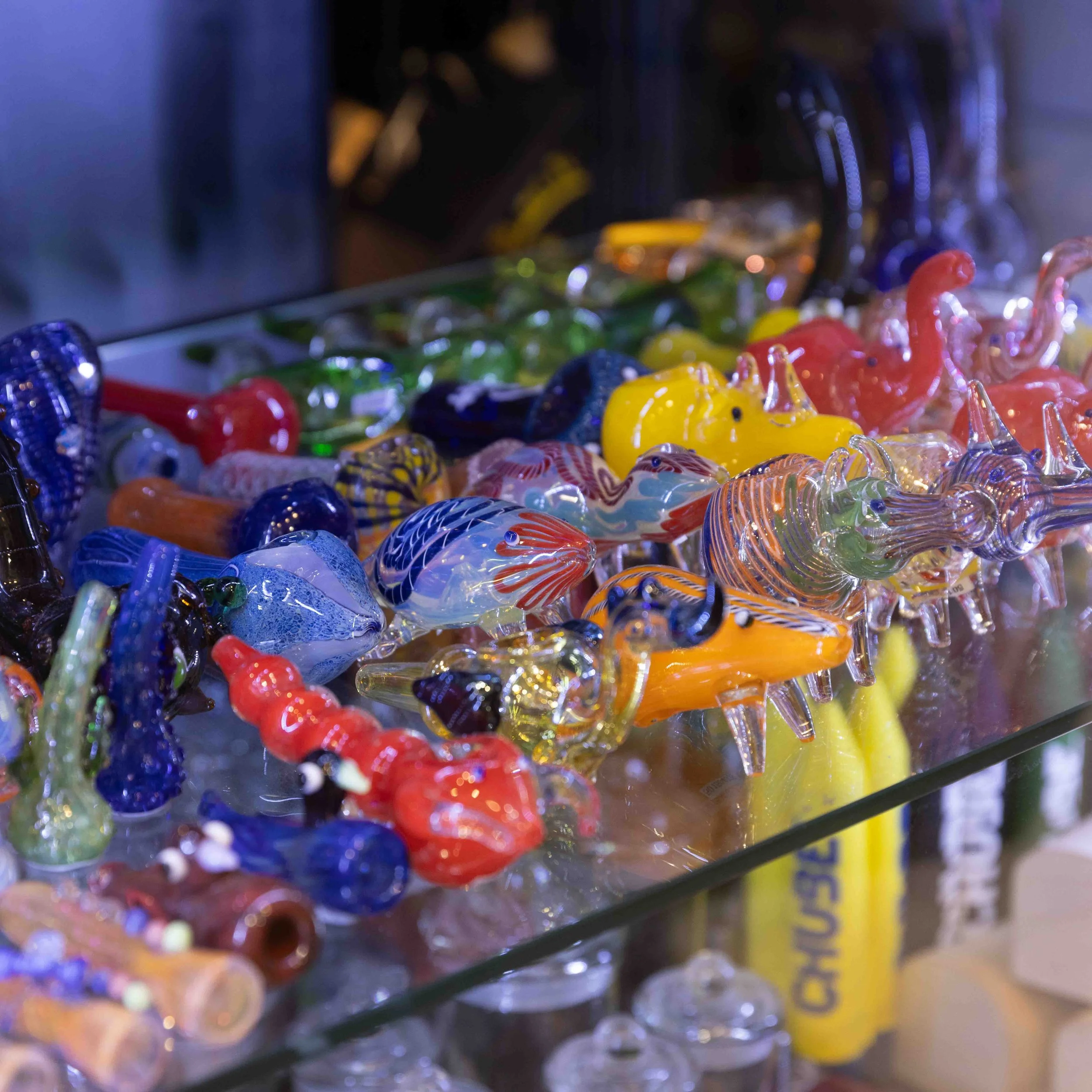 Colorful glass figurines resembling sea creatures displayed on a glass surface.
