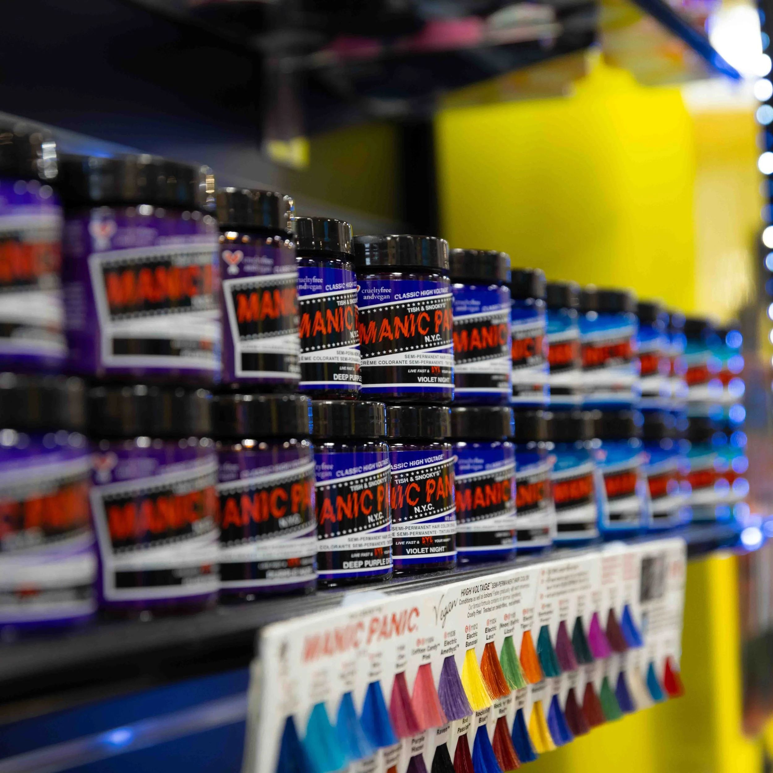 Shelves with jars of semi-permanent hair dye in various colors, including deep purple and violet night, displayed in a store.