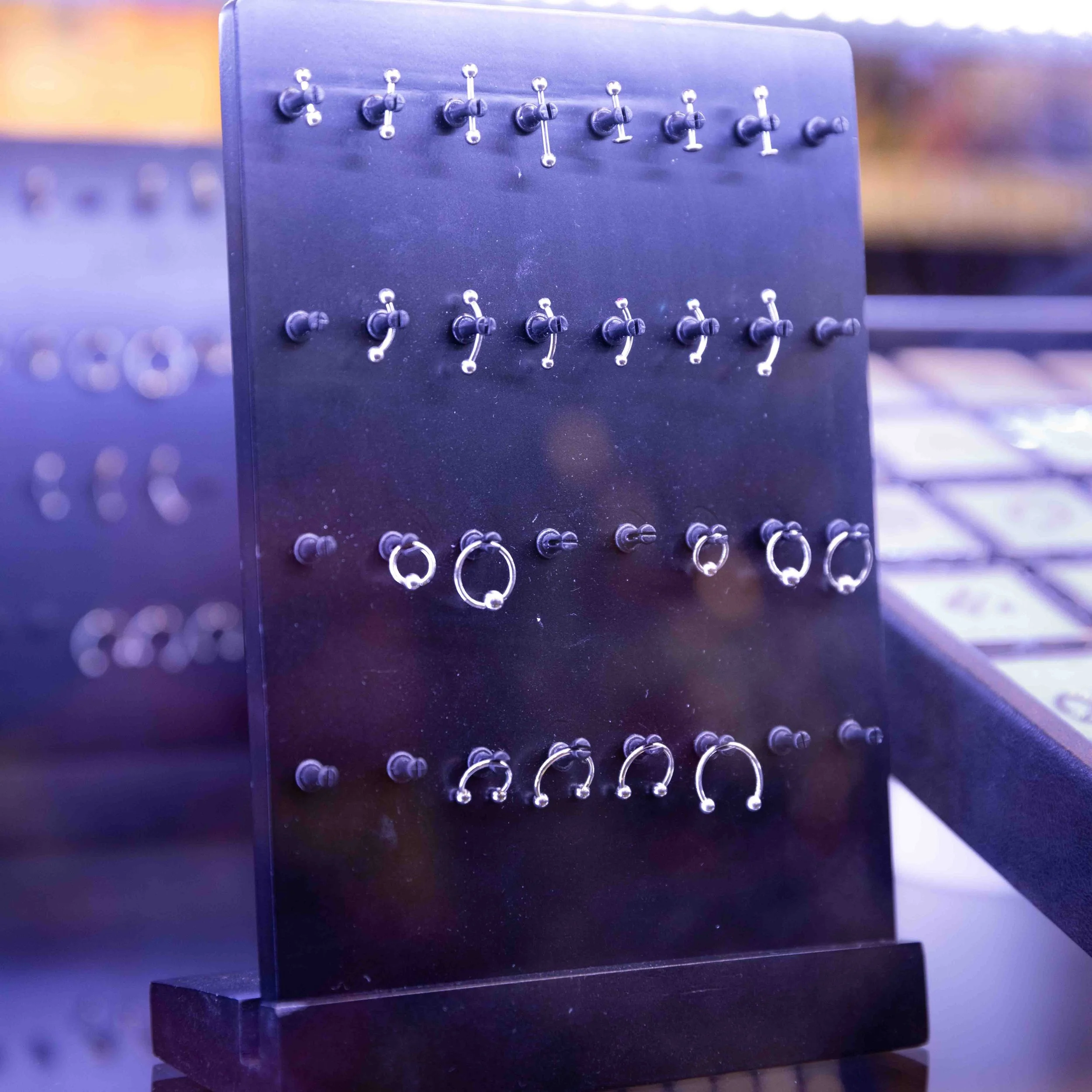 A display stand with various silver hoop earrings arranged in rows.