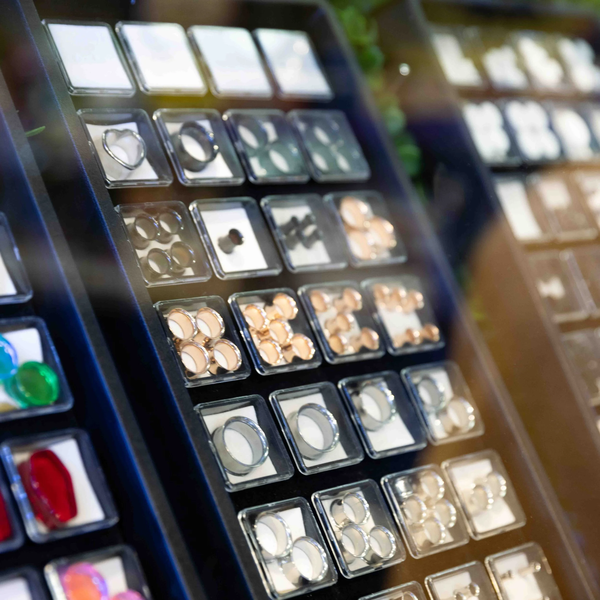 Display of various rings and jewelry in a jewelry store with organized small compartments