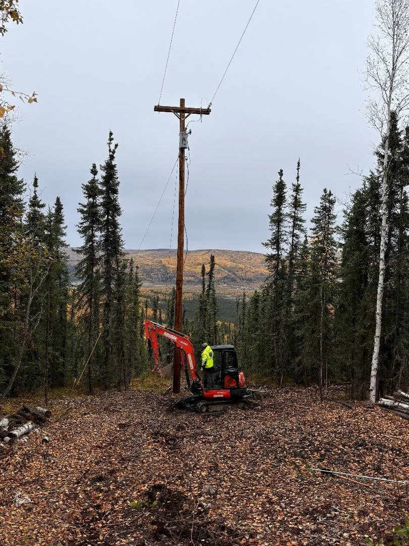A man driving a red mini excavator