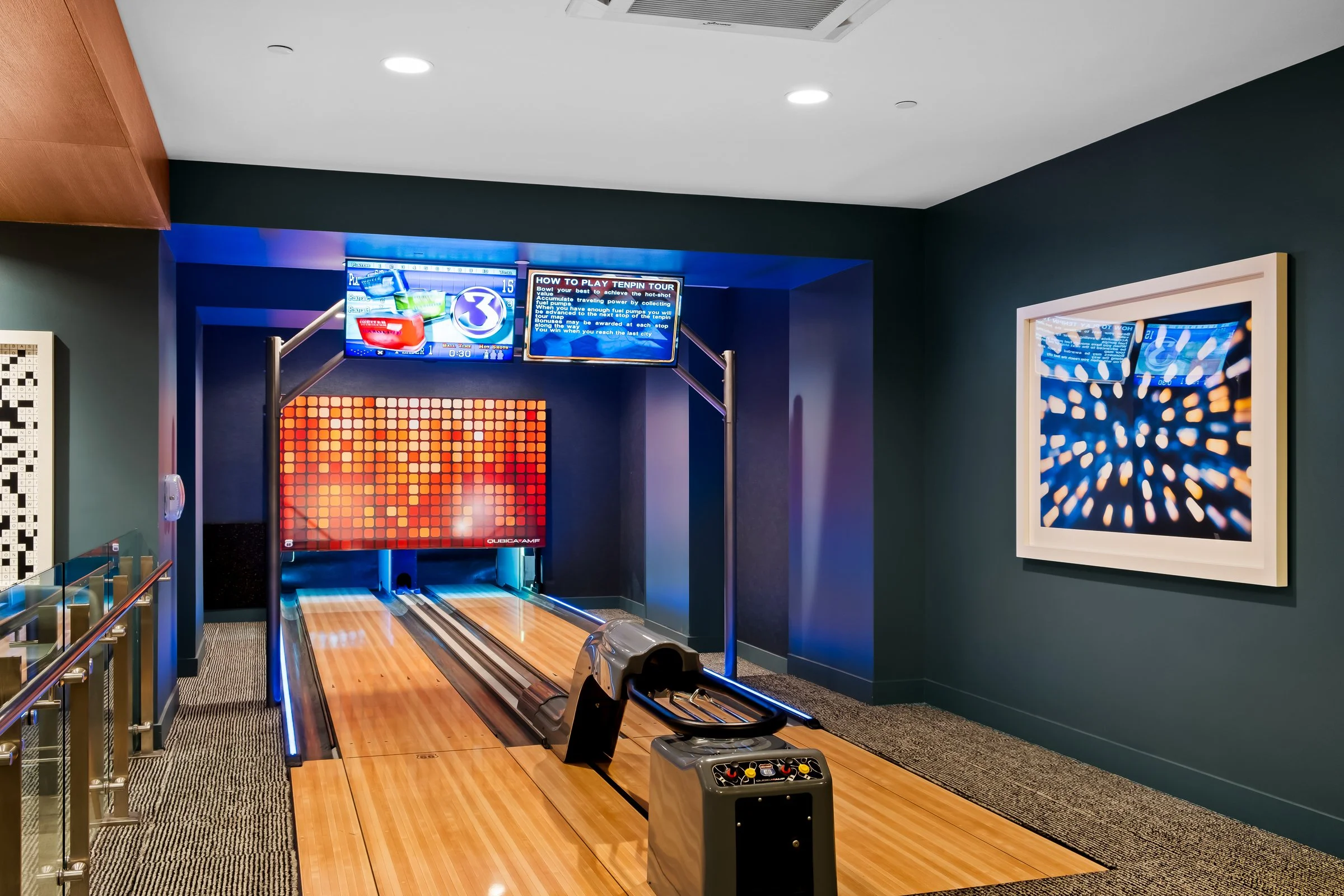 Indoor mini golf game with electronic scoreboard and colorful artwork on the walls.