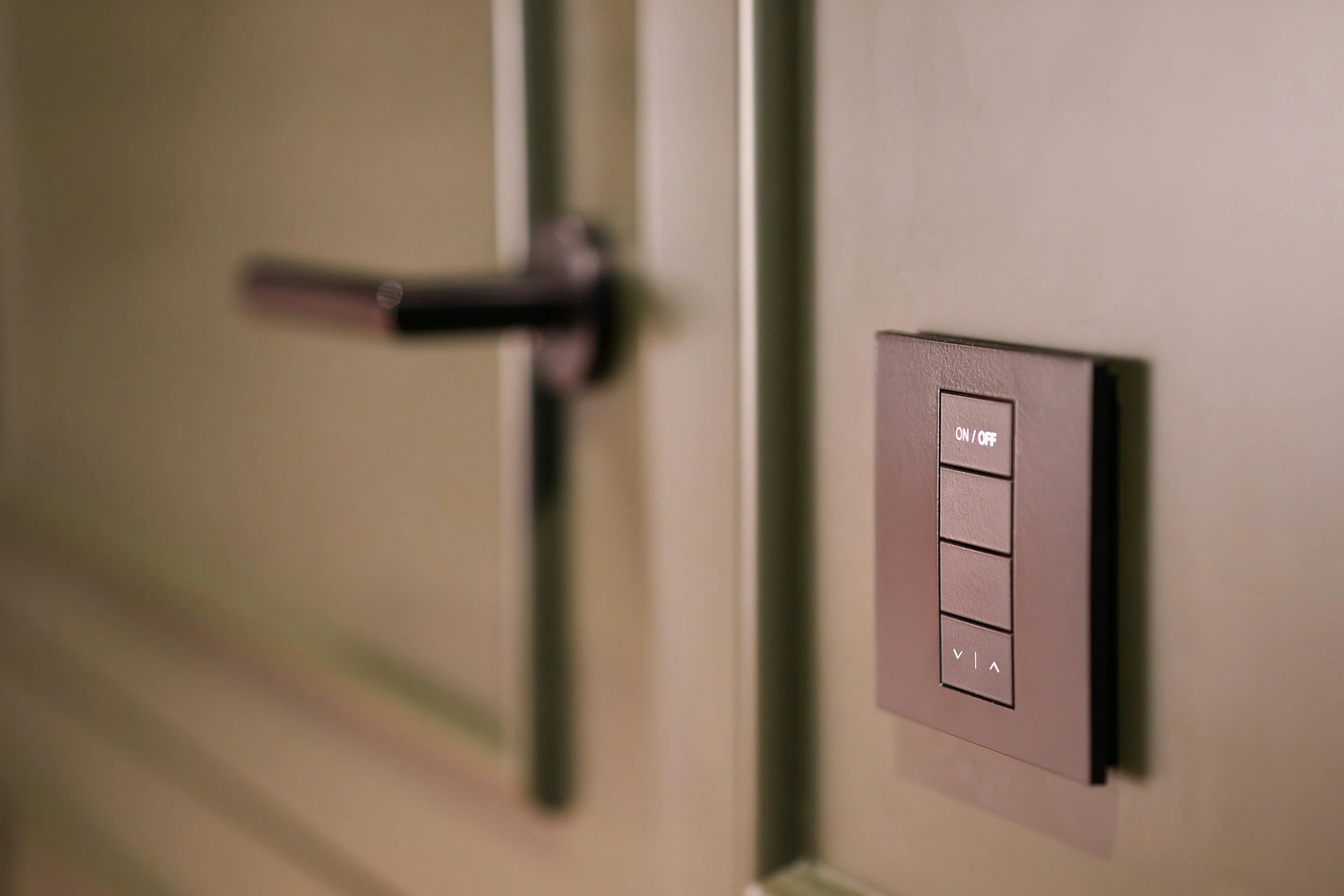 Close-up of a metallic door handle and a brown control panel with an on/off switch and up/down buttons.