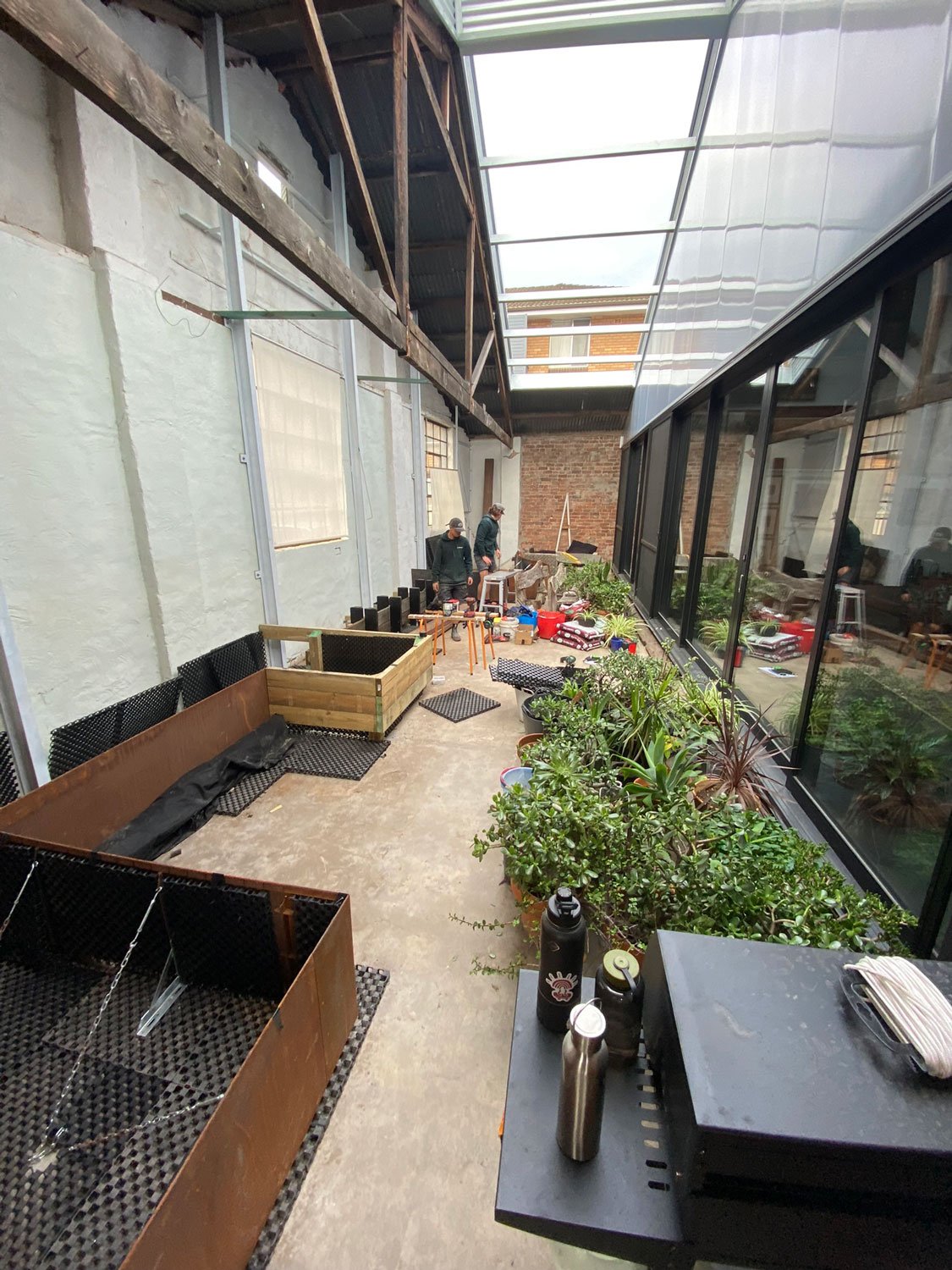 TG-Gardenscapes_Our-Projects_Waratah-Warehouse_Indoor-Raised-Garden-Beds-being-Created-with-Workers.jpg