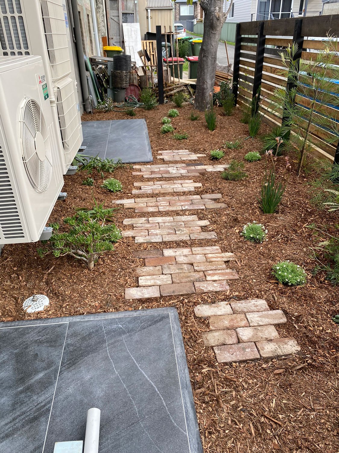TG-Gardenscapes_Our-Projects_Waratah-Warehouse_Brick-Pavers-in-Garden-with-Wood-Chips.jpg
