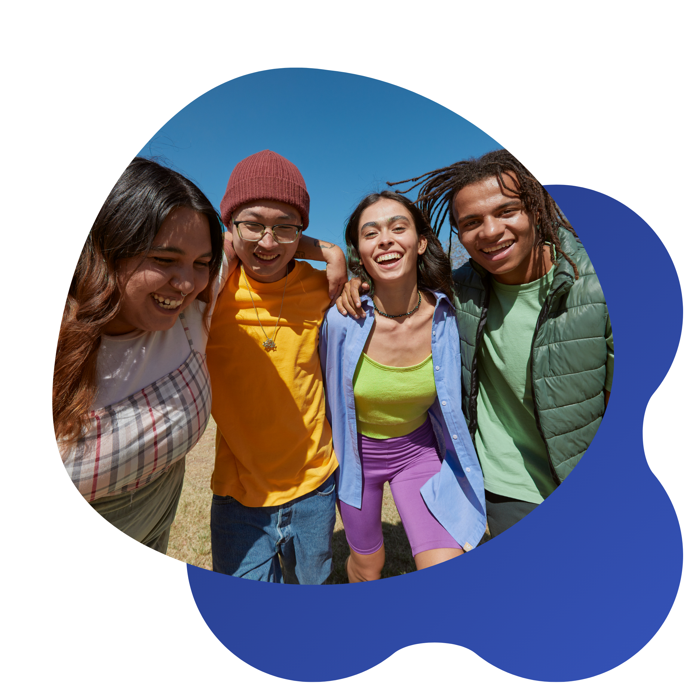 Group of five friends smiling and hugging outdoors on a sunny day, with clear blue sky in the background.