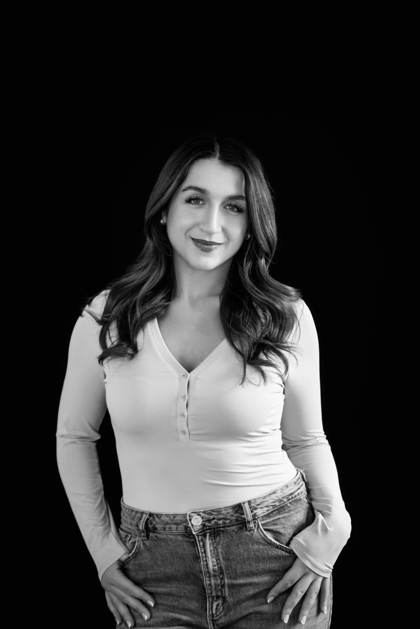 PR Team Member Julie, posed in front of a dark backckdrop. Image is in black and white.